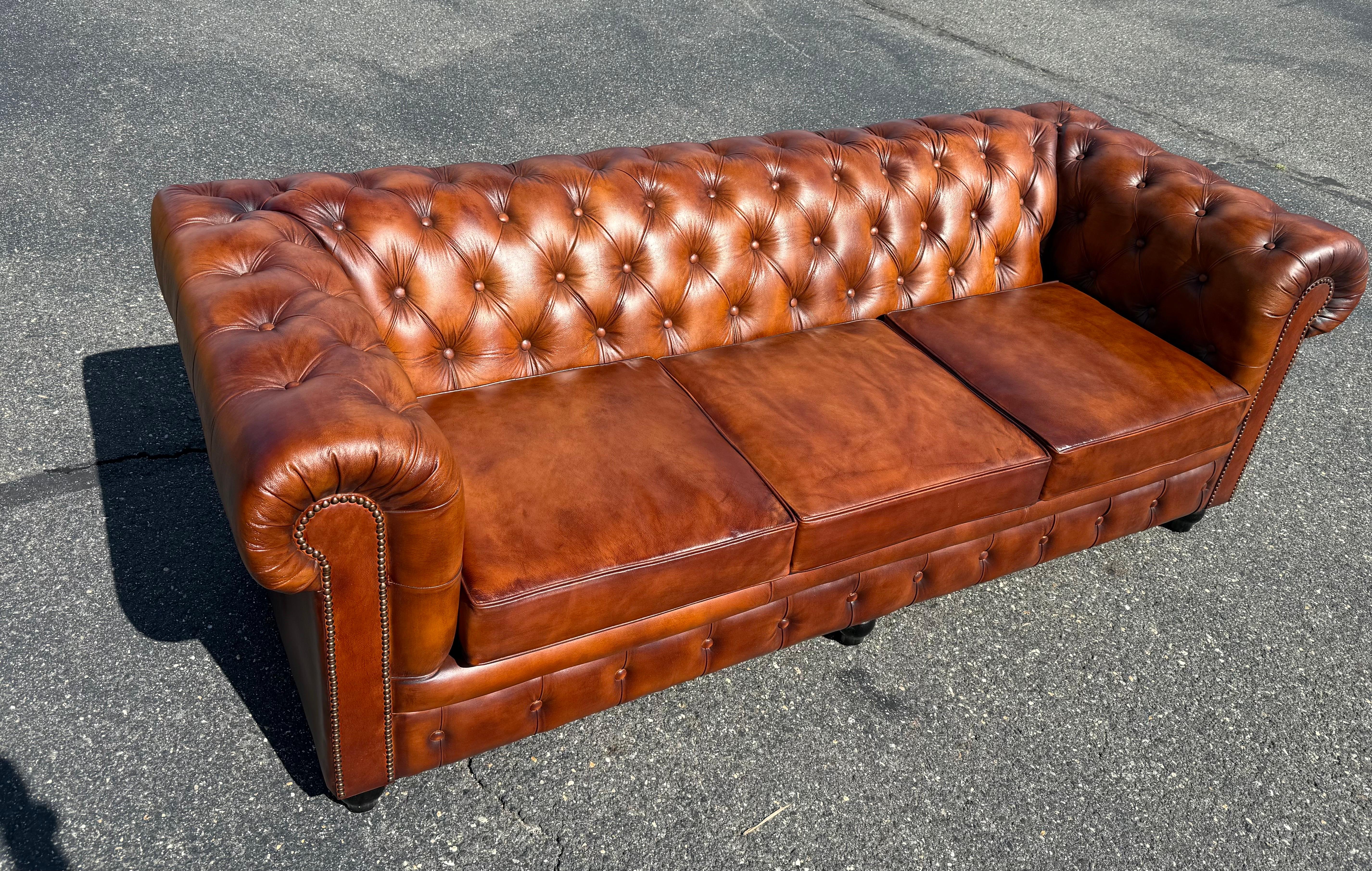 Ce canapé Chesterfield anglais sur mesure en cuir véritable brun cigare est une pièce d'apparat intemporelle, alliant confort luxueux et design classique. Doté d'un dossier et d'accoudoirs profondément boutonnés, d'accoudoirs roulés et d'une