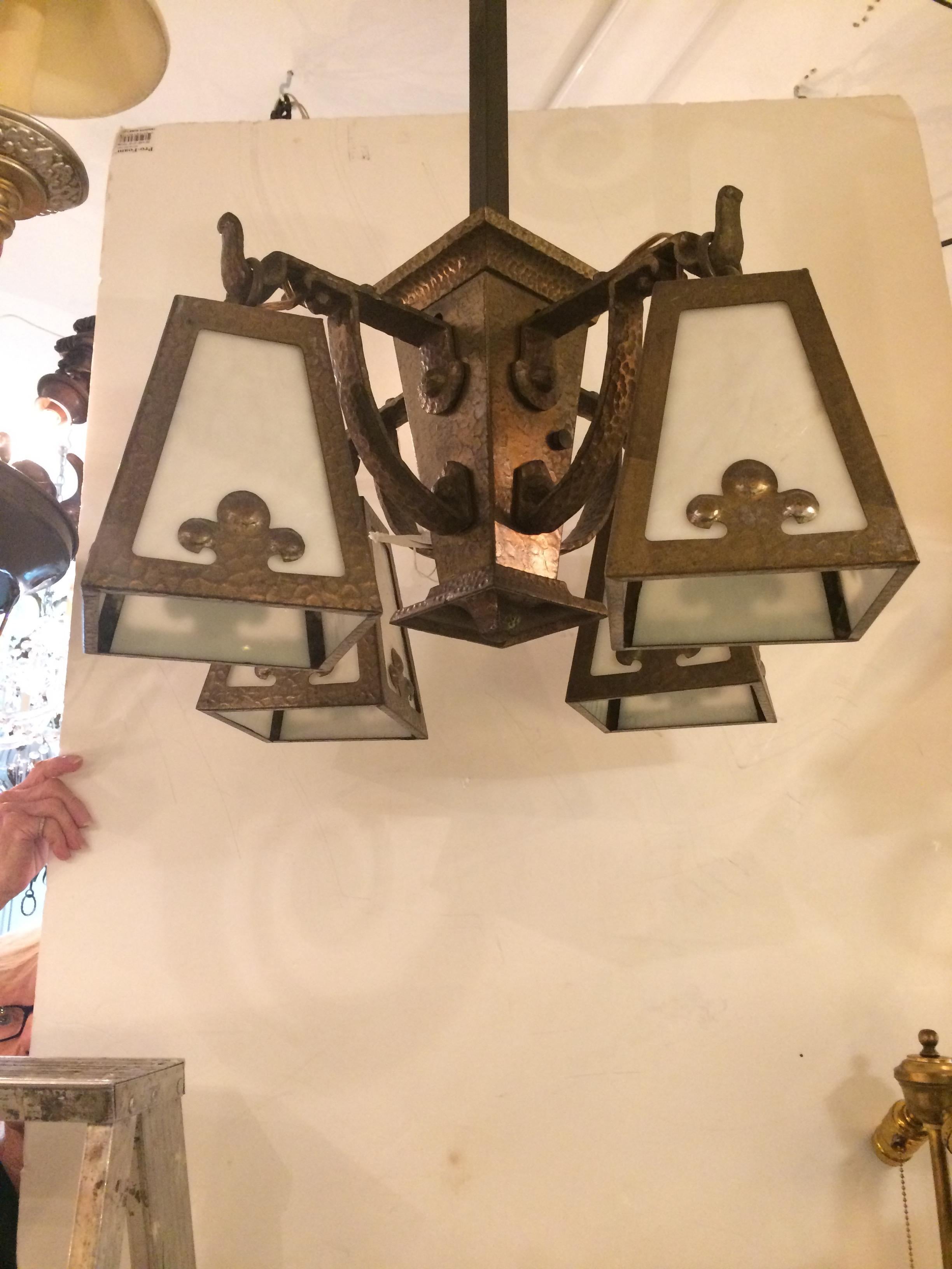 Impressive Arts & Crafts hammered brass light fixture having four white art glass shades with Fleur-de-lis motif, a long brass square rod and matching original ceiling cap. Rewired with porcelain sockets.
Shades are 7.5 inches height 5.5 wide
Rod