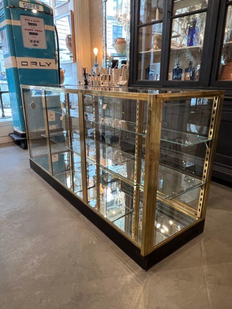 Elegant and beautiful old shop display case / vitrine counter, from a handbag boutique in Avignon.

From France of the 1930s, super stylish, and with 2 continuous separate glass shelves resting on chrome shelf brackets.

Note too the quality brass