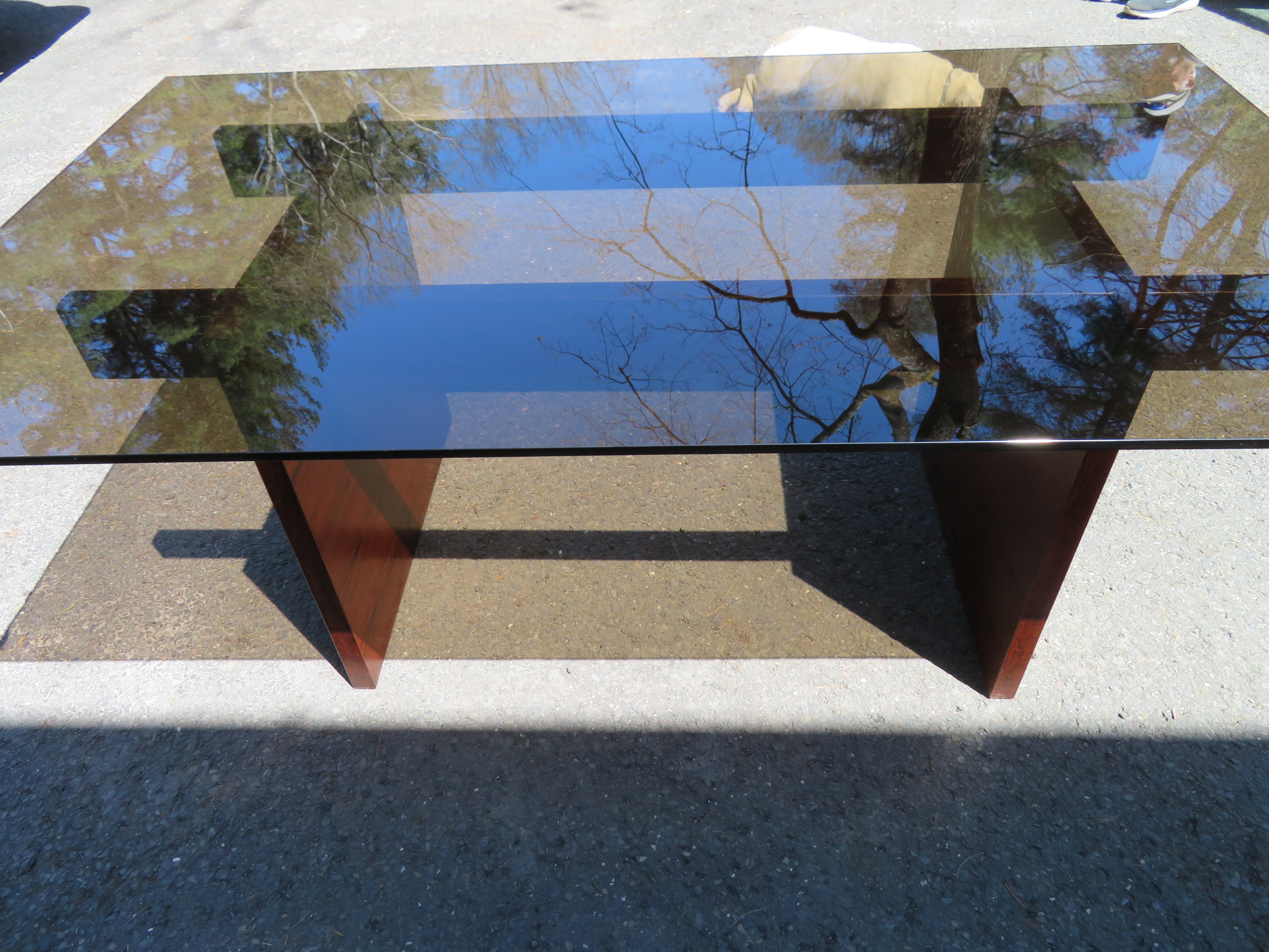Fantastic Danish Modern dining table with smoked glass top by Poul Norreklit for Sigurid Hansen Mobelfabrik, Denmark, circa 1960's. Wonderful simple rosewood base with 1/2