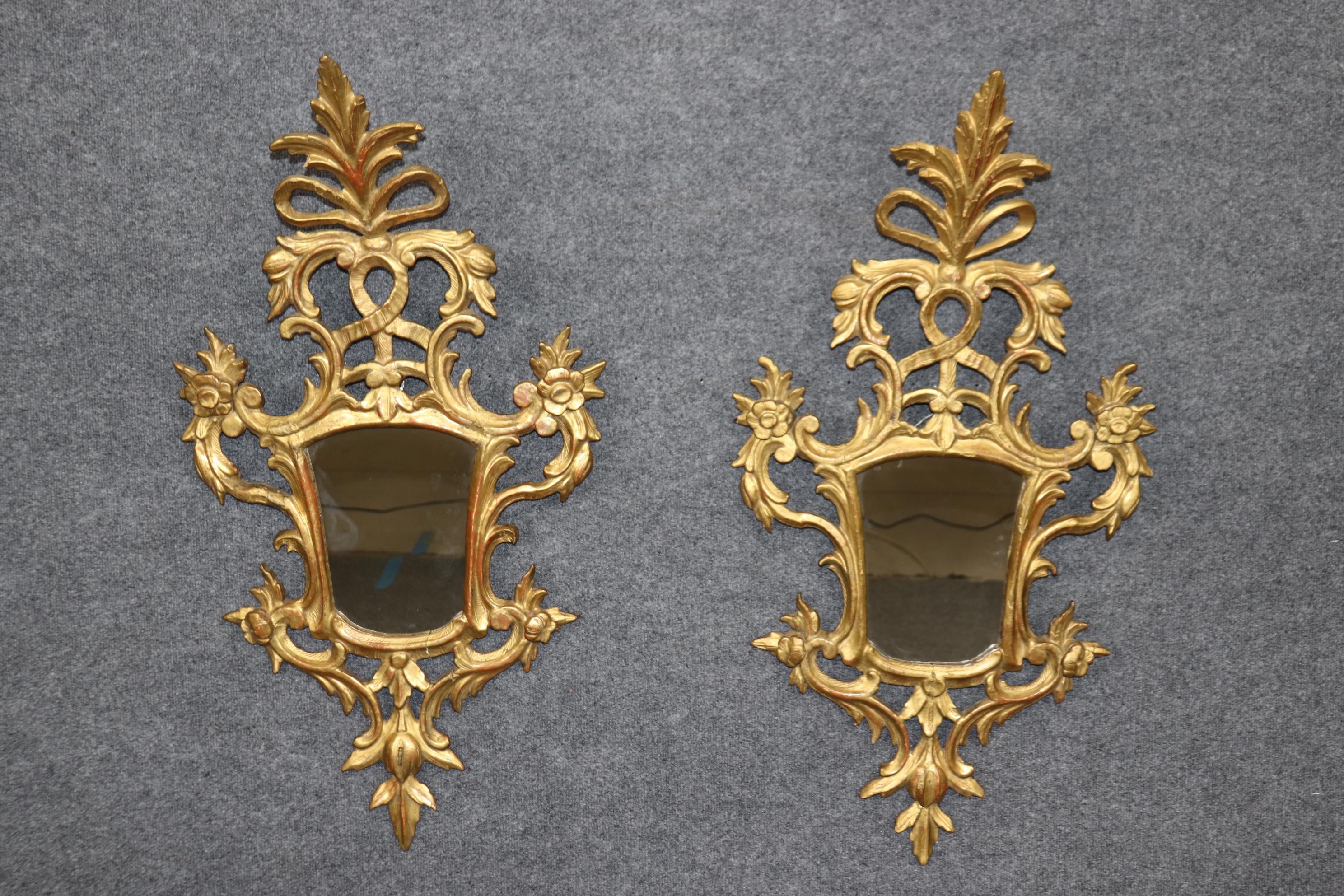 These gorgeous little gems are from the 1820-1840s era and Italian, possibly Florence. The mirros are gracefully carved of beech wood and covered in a genuine 23 kt water gilt finish over Italian red bole clay ground. They do have signs of age such