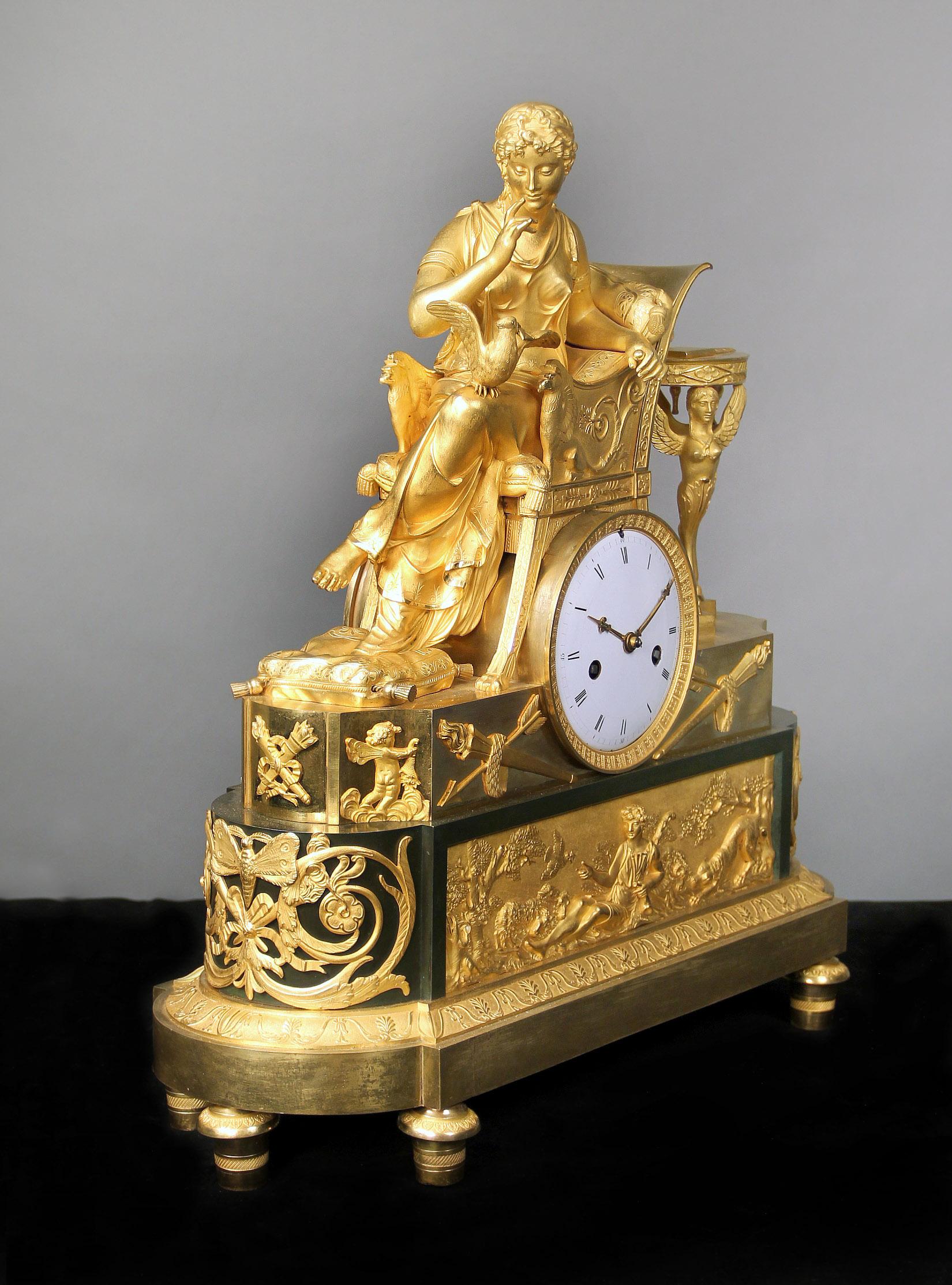 Fantastique horloge de manteau de style Empire du début du 19e siècle en bronze doré et patiné

Un grand bronze doré, une belle femme assise sur une chaise bergère en forme de griffon, appuyée sur des coussins et songeant à un oiseau perché sur sa