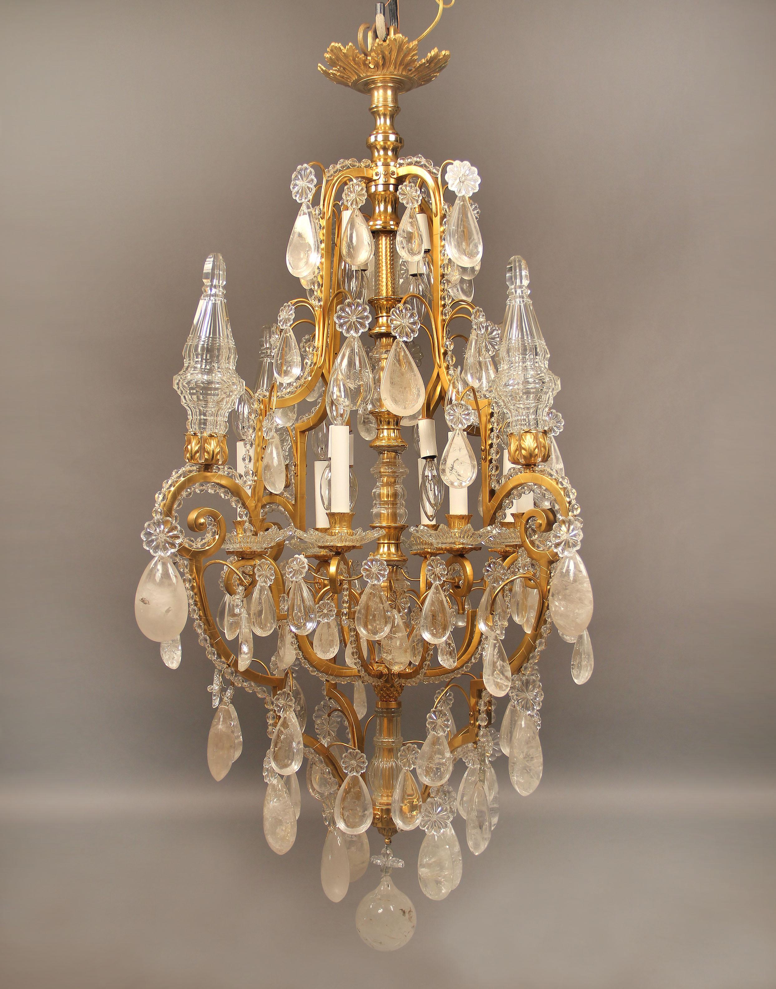 A lovely and fantastic early 20th century gilt bronze and rock crystal sixteen-light chandelier.

Tear shaped rock crystal, beaded arms, cut crystal central column, four spears with eight perimeter and eight interior lights.