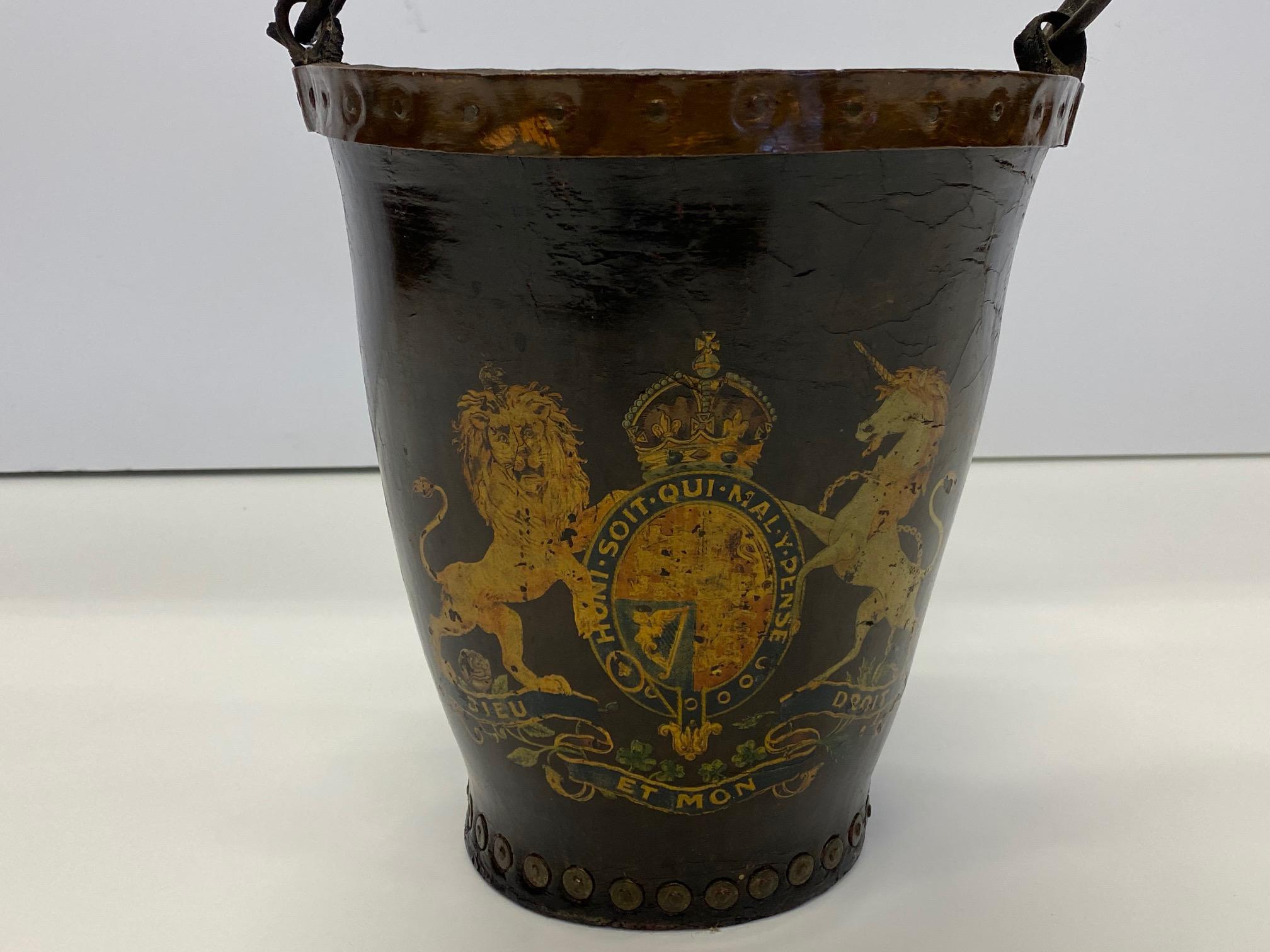 A fabulous character rich early English fire bucket, hand painted with regal crest of two horses and oval medallion with crown. Original leather handle.