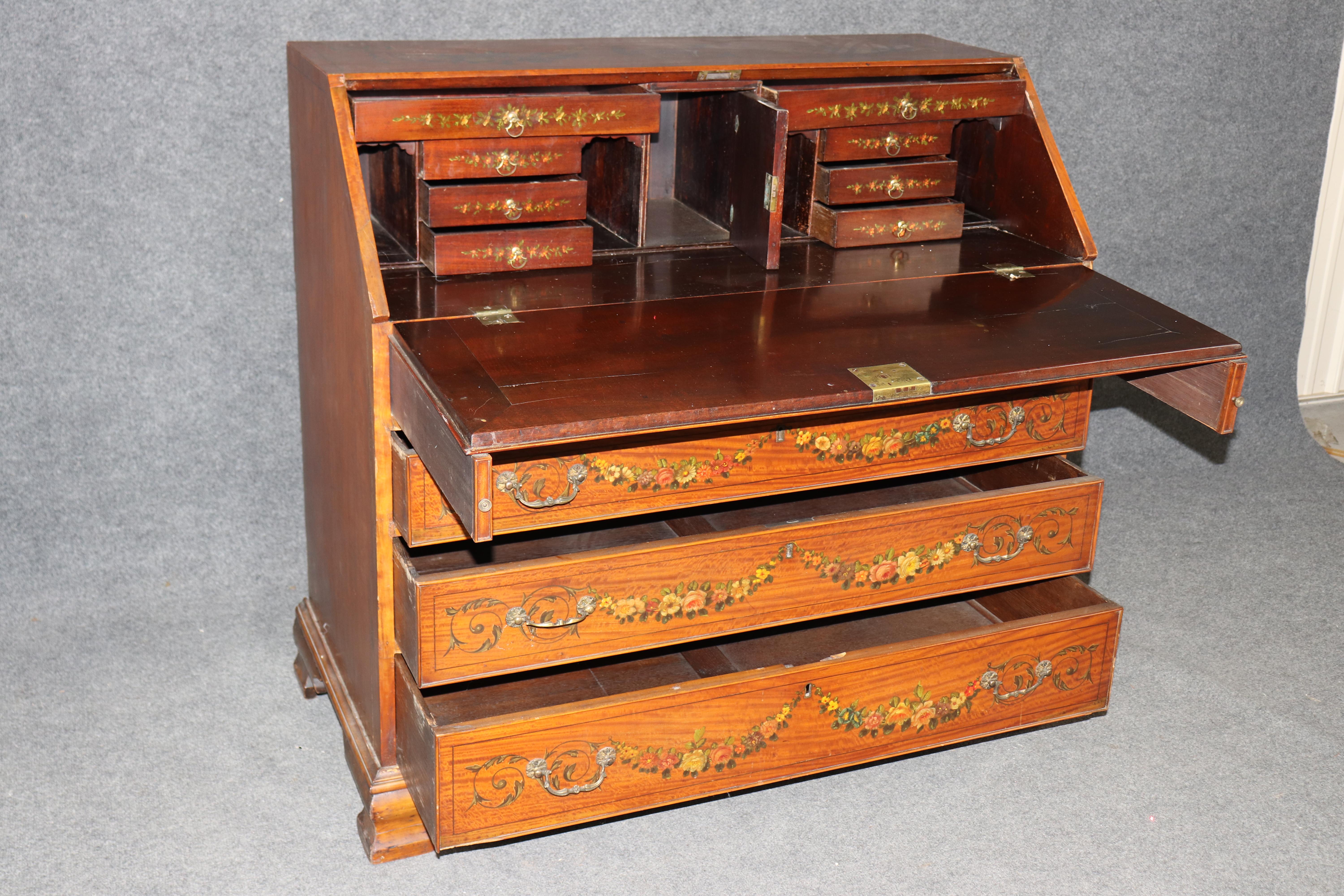 Se trata de un magnífico escritorio Adams de madera de satén decorado con pintura, fabricado en Inglaterra en la década de 1880. El escritorio luce escenas y temas florales magníficamente pintados y reluciente madera de satén. El escritorio muestra
