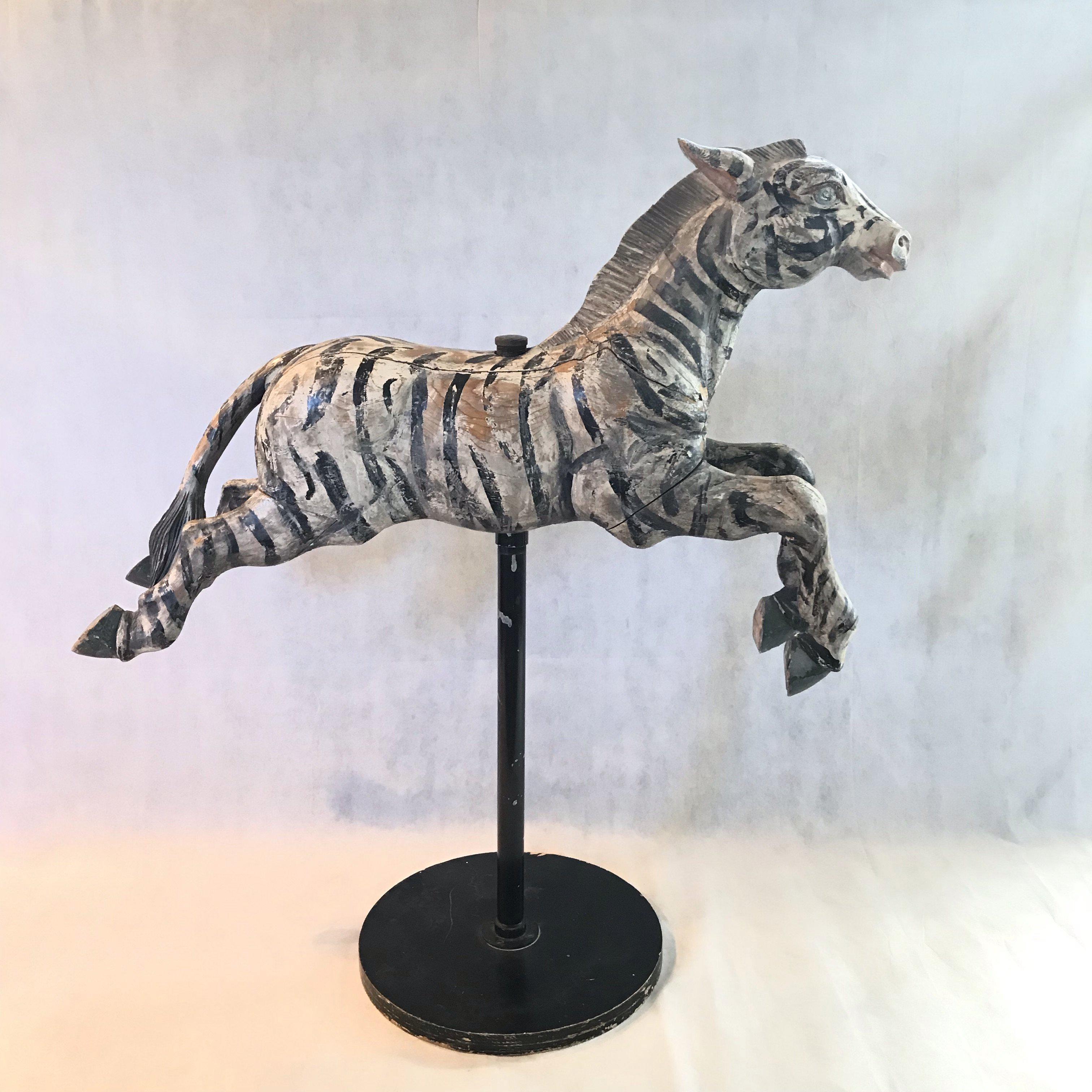 Fabulous hand carved, original paint, wooden Merry-go-round Zebra horse on stand. This large hand painted and hand carved carousel zebra is made of wood and retains its original black and white paint and blue eyes. There is a hole through the body