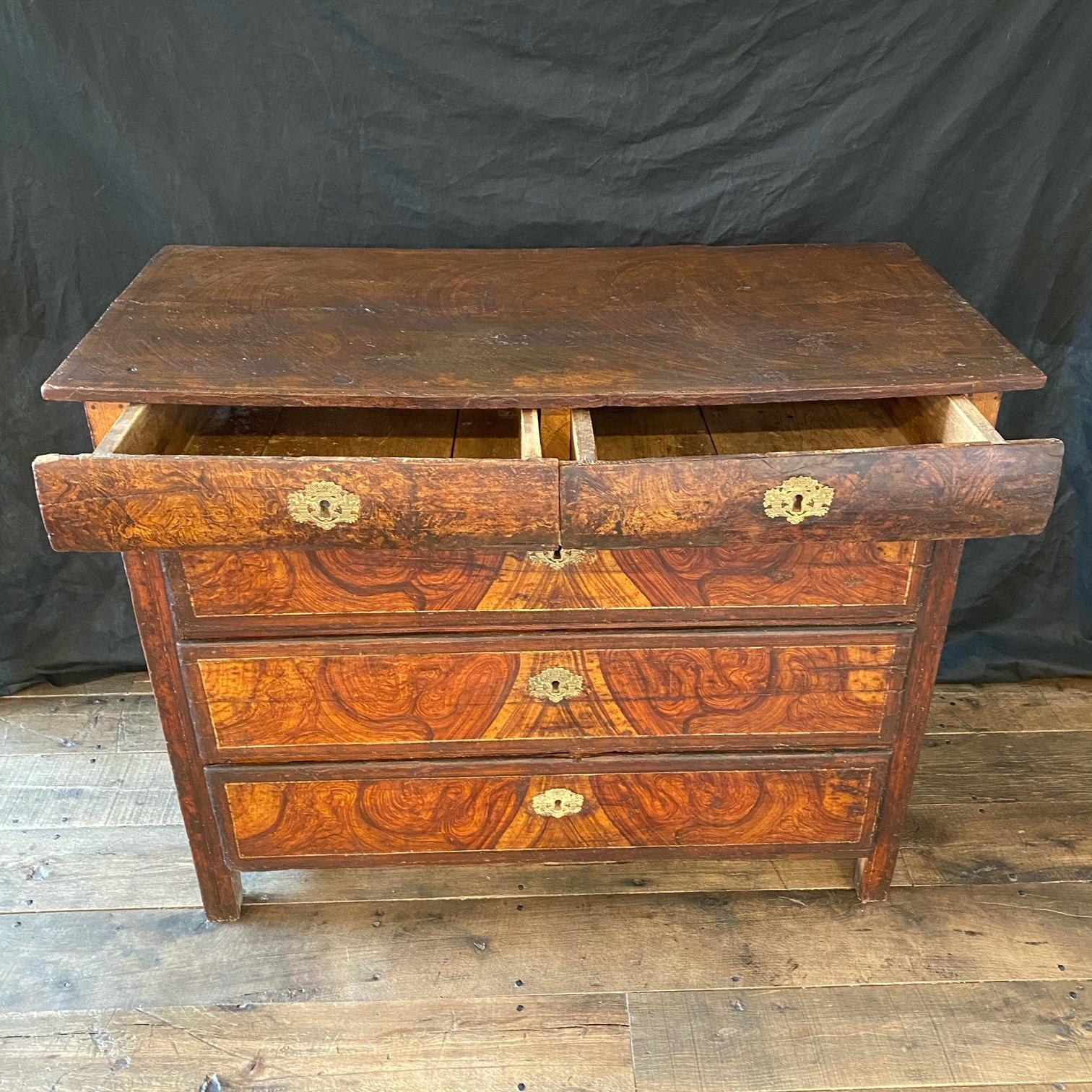 This super early faux grain painted commode or chest of drawers was found in the South of France having 5 drawers painted to look like wood grain with gold gilt borders on the drawer fronts. 18th century and all original except for later but