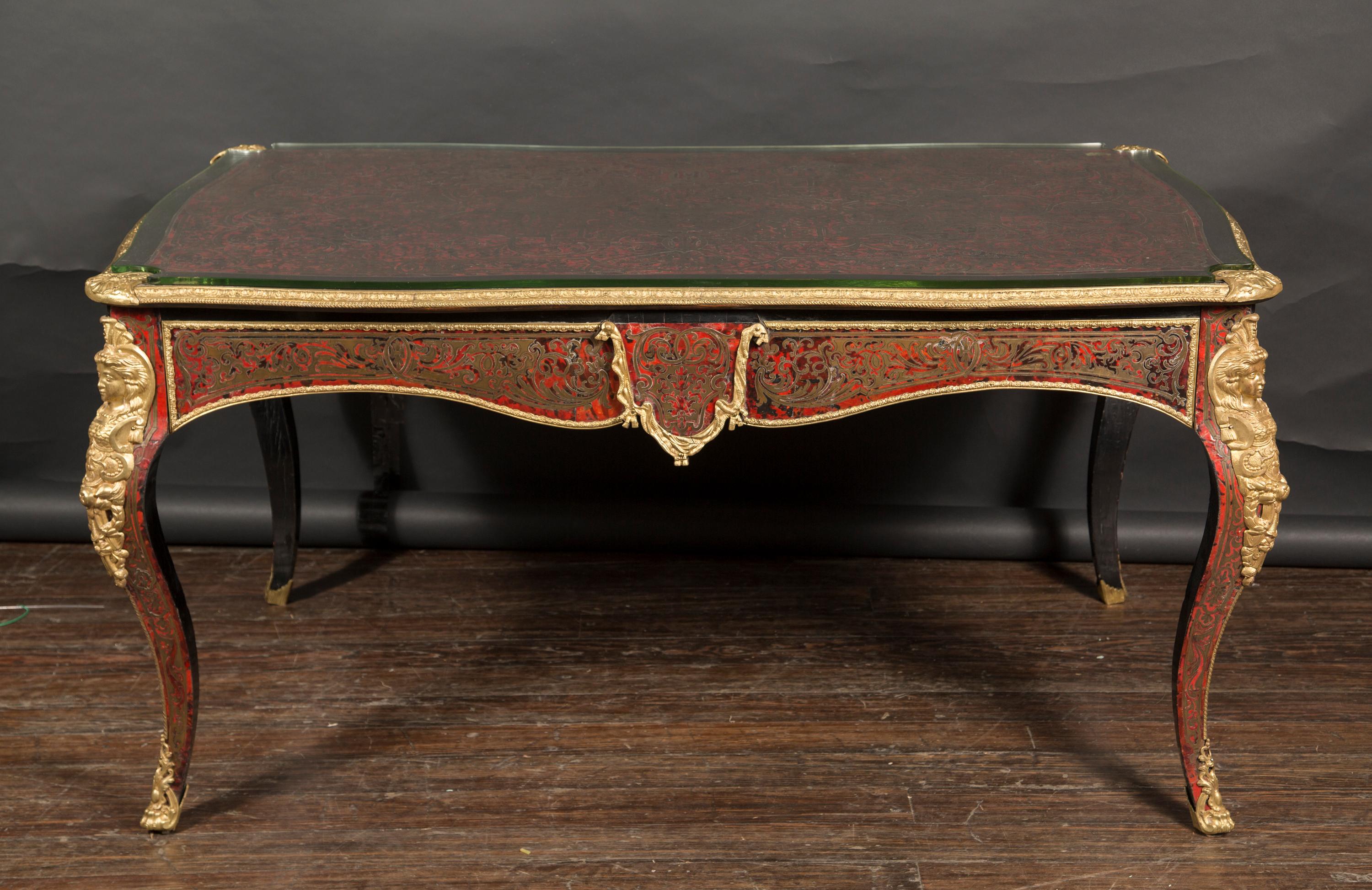 This magnificent 19th century tortoiseshell Boulle desk features gorgeous bronze mounts and sculpted brass inlaid in the tortoise shell. The desk is created in the style of Louis XV with cabriole legs, each mounted with a female allegorical figure.
