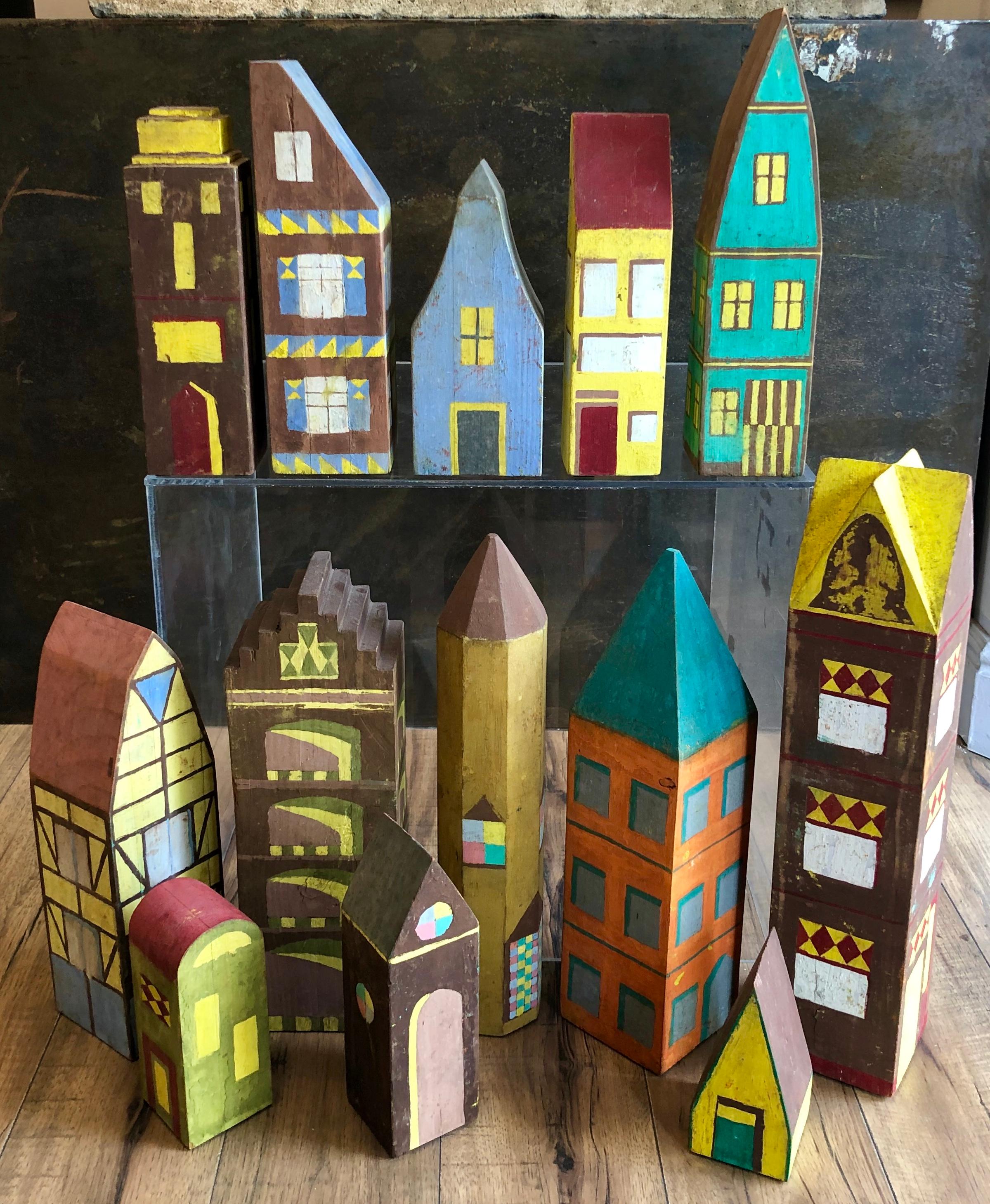 Collection of 13 hand constructed painted wood futuristic buildings creating a colorful cityscape. These were purportedly made by a professor teaching at or around Chautauqua in the 1920s. The paint is dray and early from that period. Great
