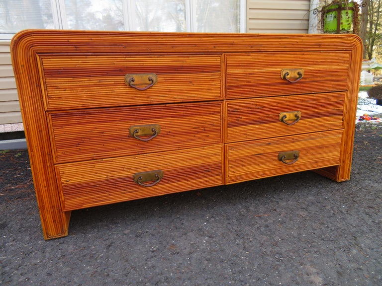 Fantastic credenza with split bamboo and brass hardware. Curved waterfall top with 6 drawers. This piece is in lovely vintage condition and ready to slip right into your luxury decor. It measures 31