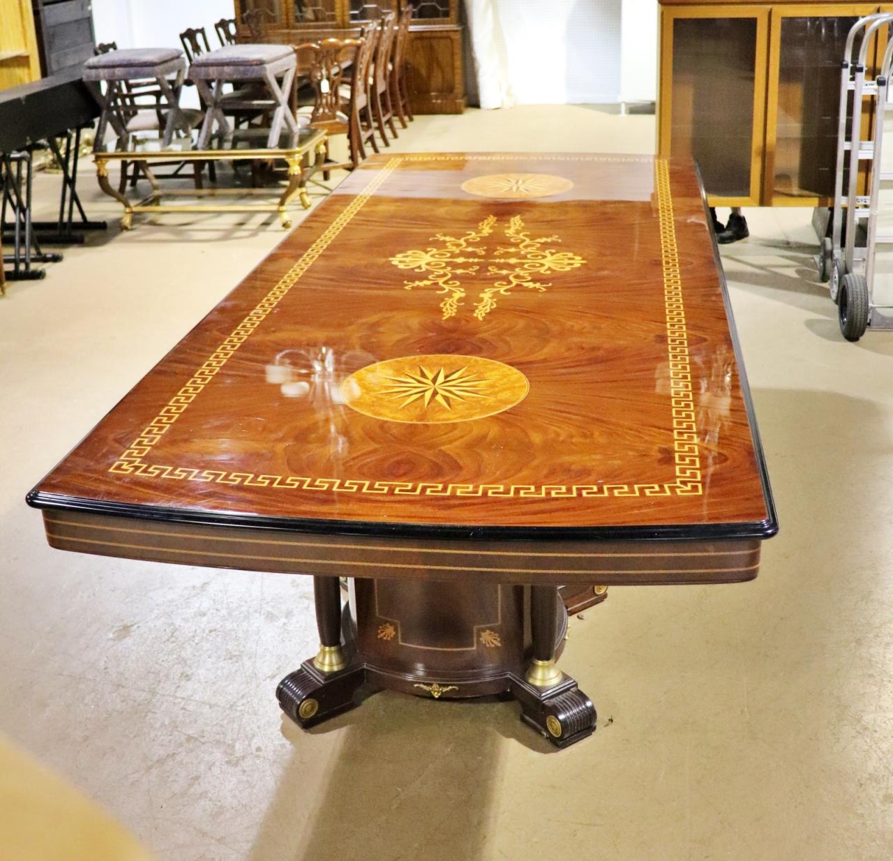 This is a spectacular dining table with mixed woods inlaid across a bed of fantastic flame mahogany veneer and bronze and ebonized elements. The table is a match to a set of 12 dining chairs we have listed separately. If you want the entire set, we