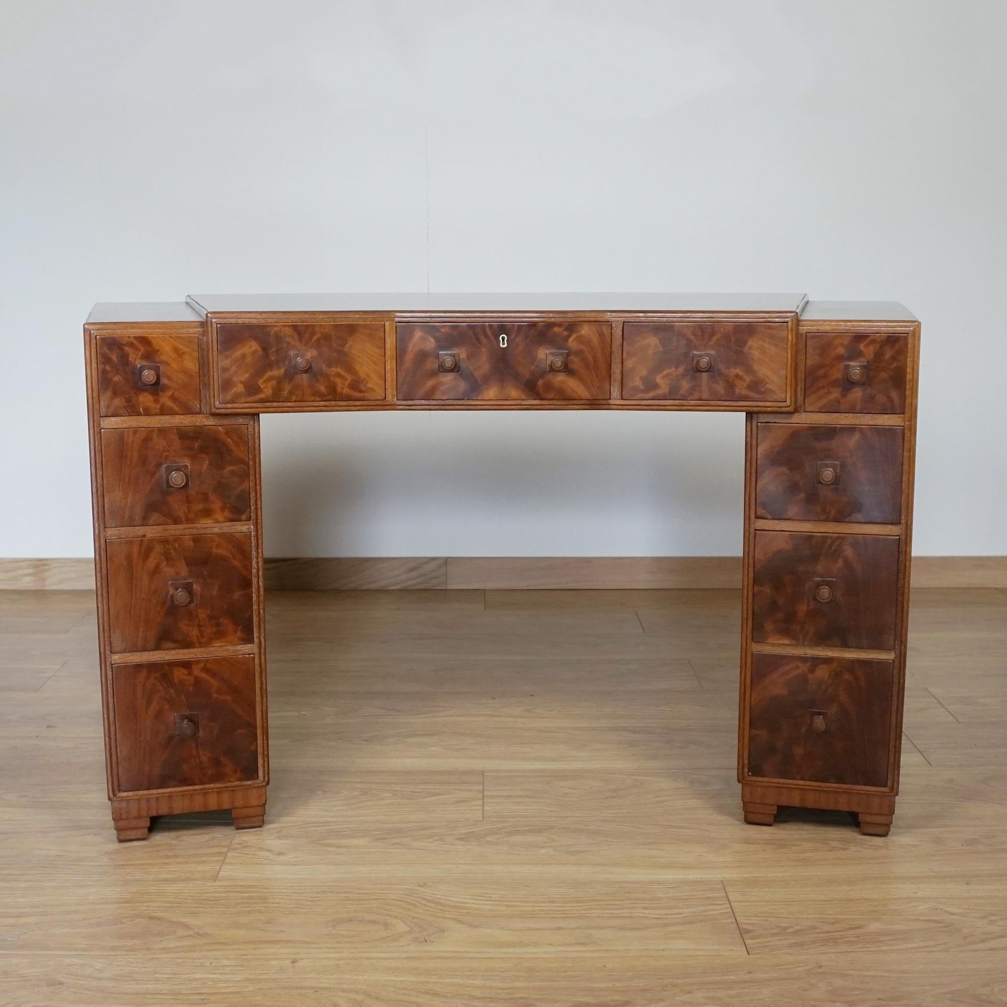 An Art Deco desk by Heal's of London. Walnut veneered all round with four graduating drawers to either pedestal and three upper central drawers. Original handles and Heal's stamp to upper right hand drawer. 

Dimensions: H 76cm W 144cm D 66cm