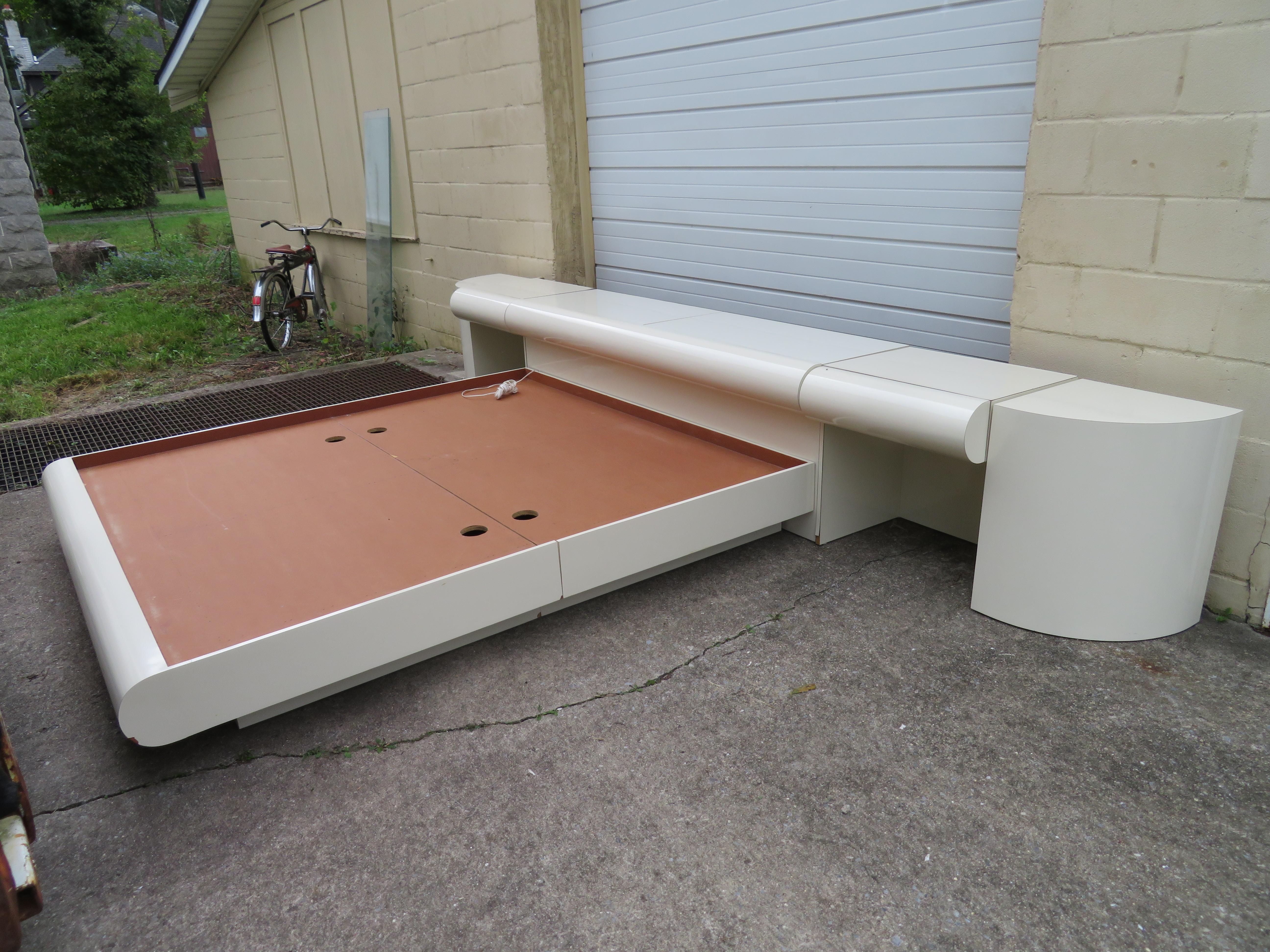 Fantastic Karl Springer style bubble front king size platform bed with matching nightstands. This set is well constructed with formica and solid wood. There are a few minor chips to formica but this set shows well. The headboard has two concealed