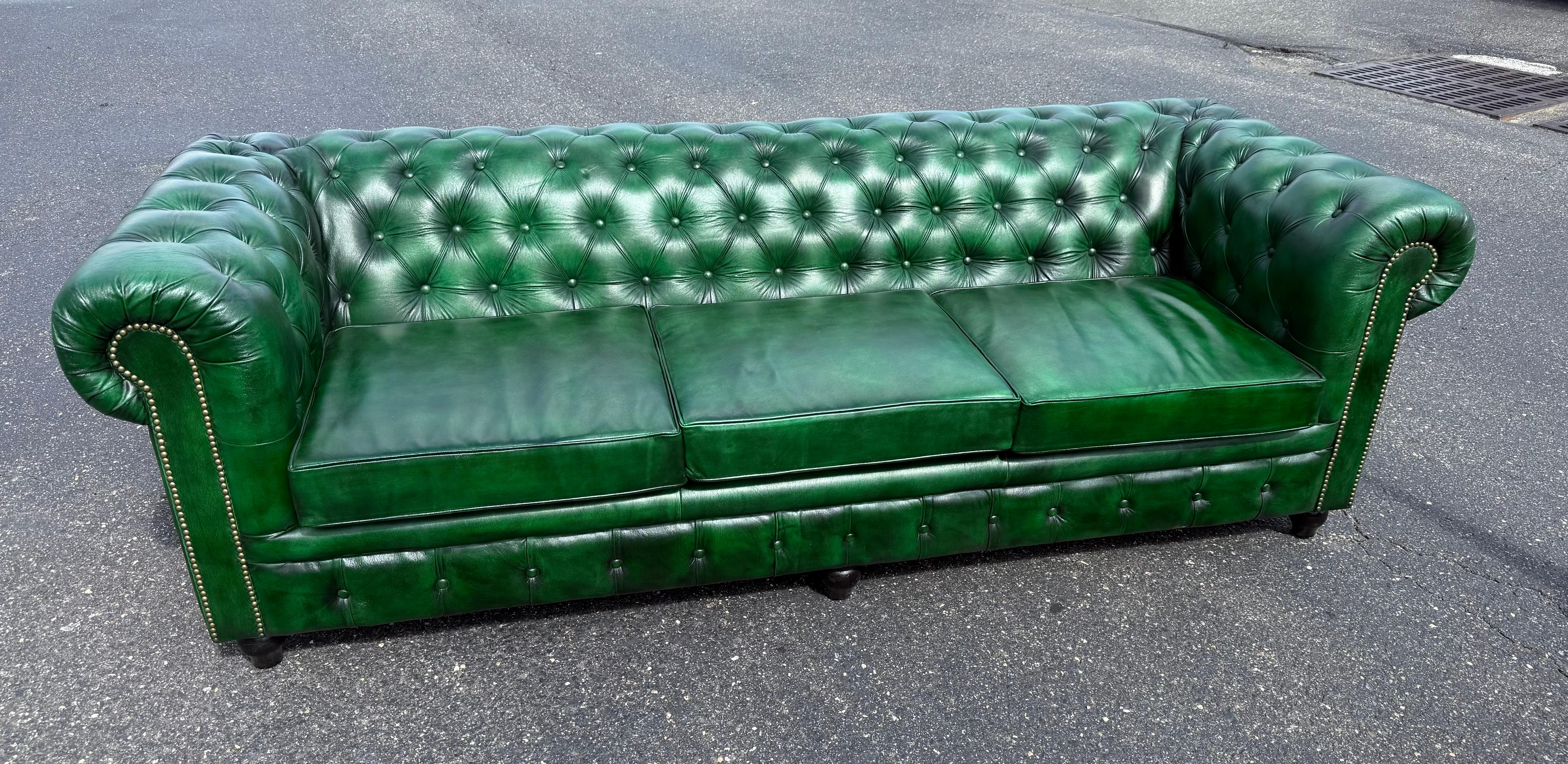 This striking custom-made English Chesterfield sofa is upholstered in genuine leather and finished in a rare and eye-catching polo green tone, making it a standout piece for any interior. Handcrafted with traditional English detailing, the sofa