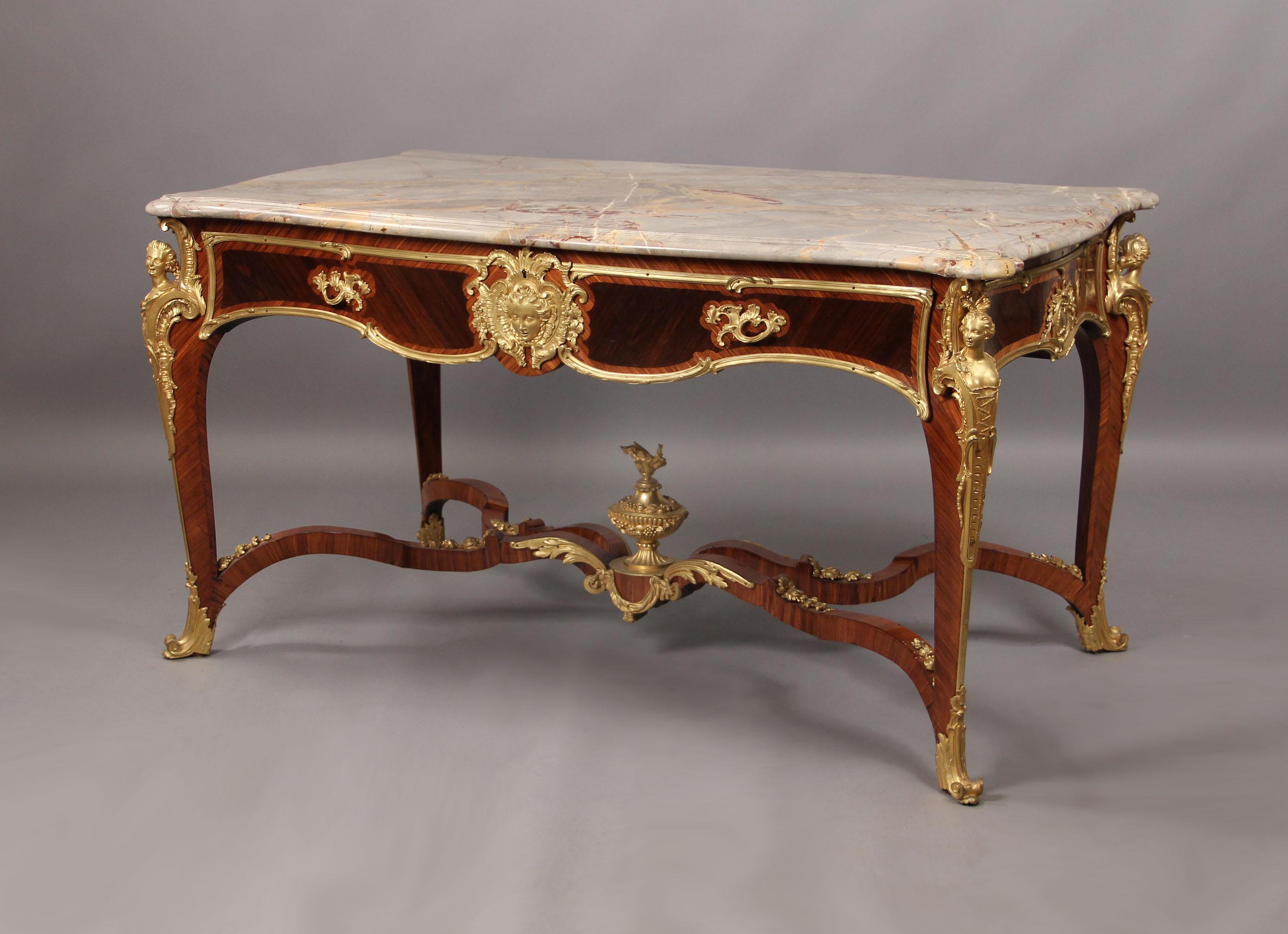 A fantastic late 19th century gilt bronze-mounted Louis XV style kingwood centre table

By François Linke

With serpentine-grey and yellow marble top, above a frieze drawer centred by a female mask cartouche, the sides each centered by a