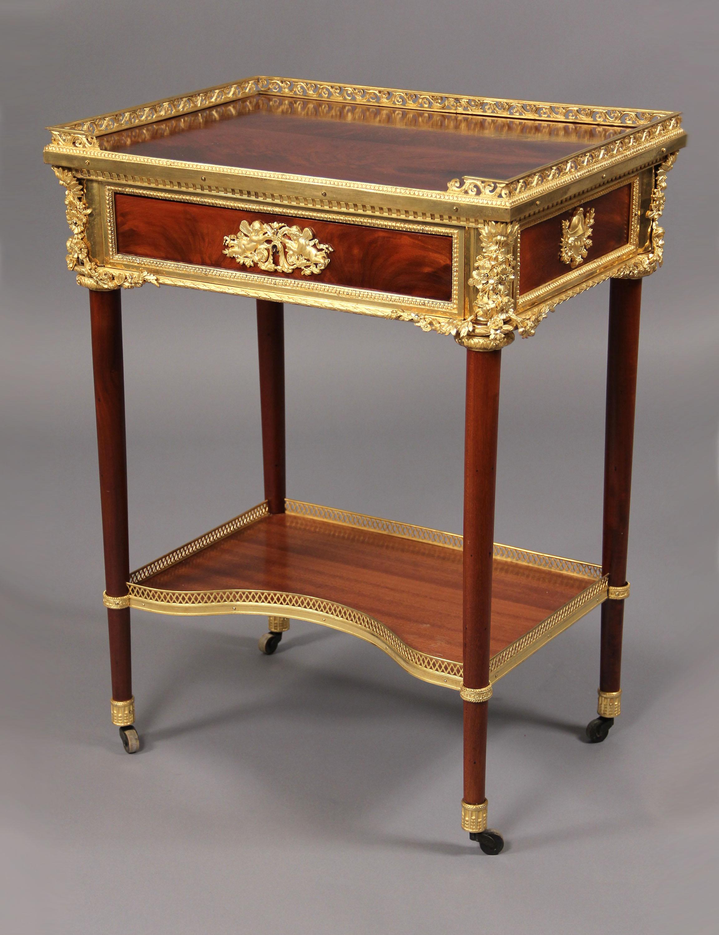 Fantastique Gueridon de la fin du 19ème siècle de style Louis XVI monté en bronze doré d'après Riesener

Le plateau rectangulaire en acajou plaqué à la flamme avec une galerie trois-quarts percée, au-dessus d'un tiroir à frise unique centré avec une