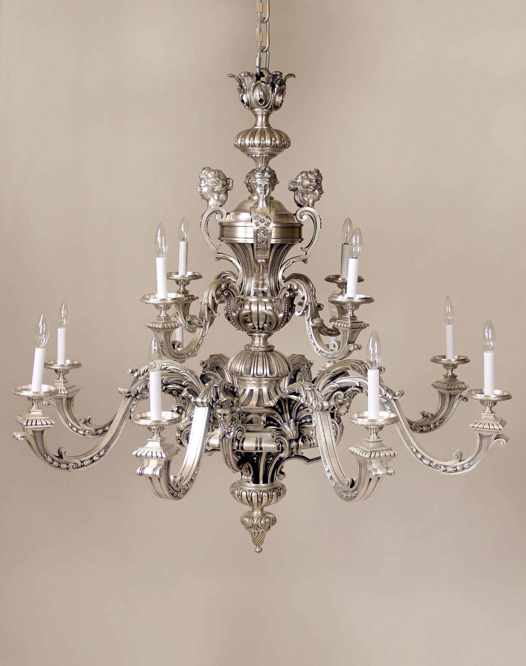 A fantastic late 19th century silvered bronze twelve-light chandelier

Wonderful quality casted frame, the top with women busts, foliage designs along the arms and body, the bottom arms with a flower motif or a female mask, twelve tiered perimeter