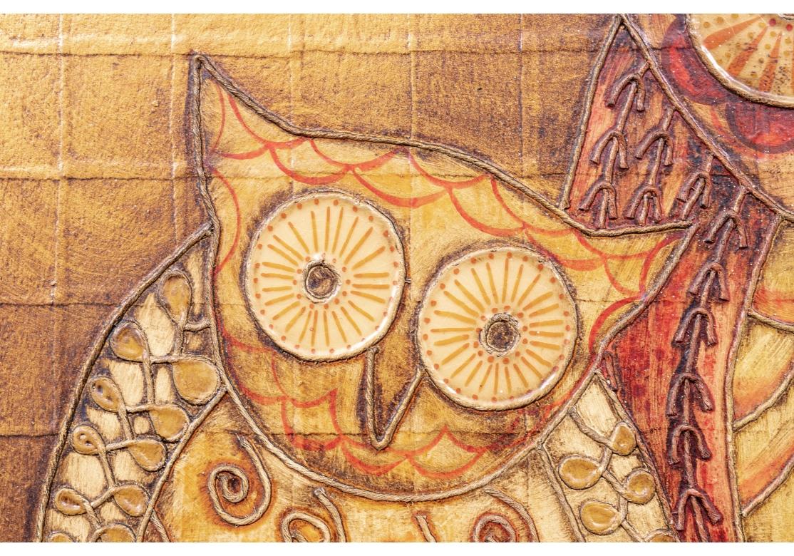 Mixed media on panel. Made in Mexico ca. 1970s. Label on verso. A charming Midcentury Folk Art type piece in tan and rust tones with three owls with raised decorative feathers in different patterns perched on a branch. Recessed and set into the