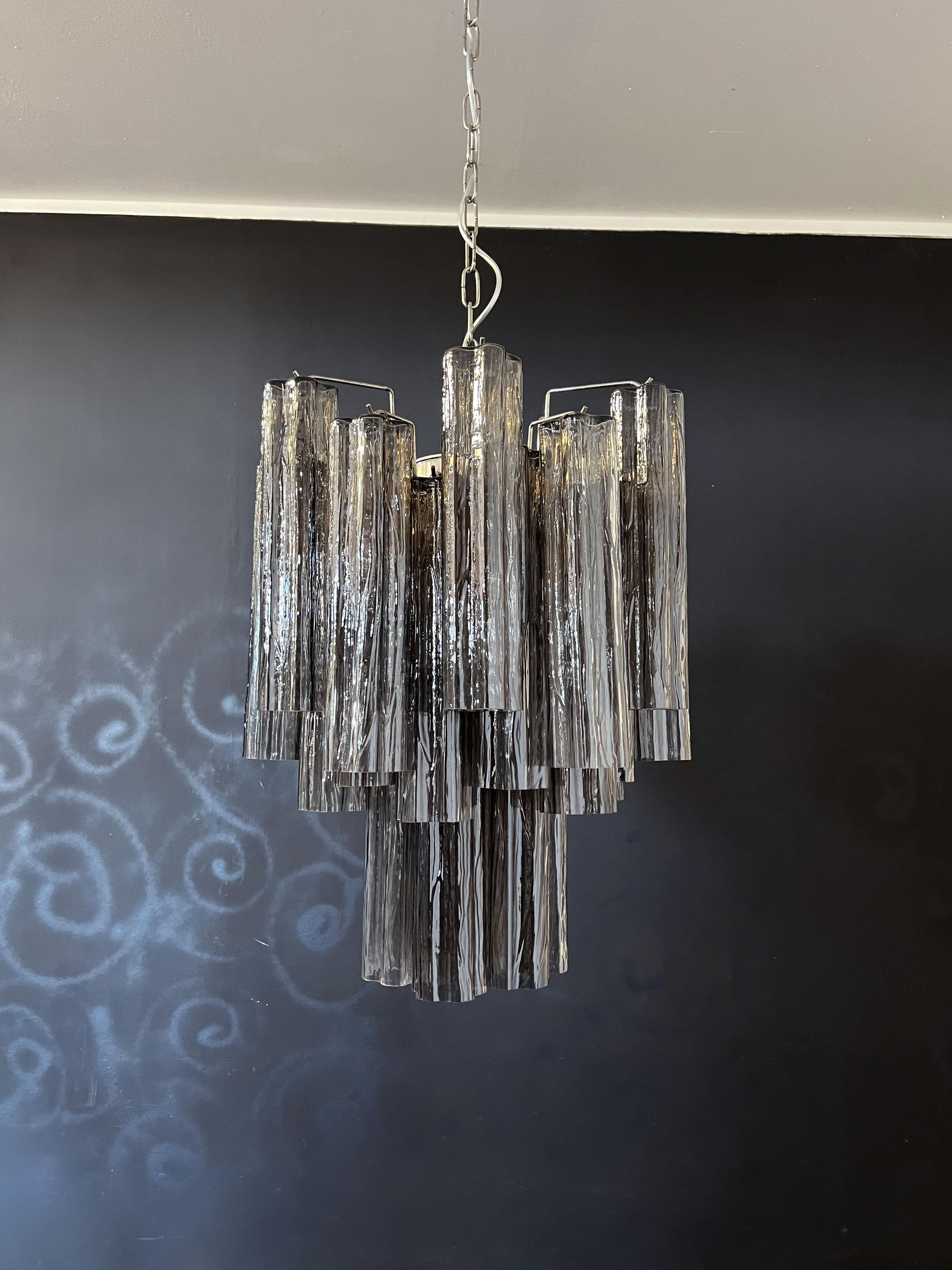 Italian vintage chandelier in Murano glass and nickel-plated metal structure. The armor polished nickel supports 30 largesmoked glass tubes.
Period: late XX century
Dimensions: 47,25 inches (120 cm) height with chain; 24,80 inches (63 cm) height