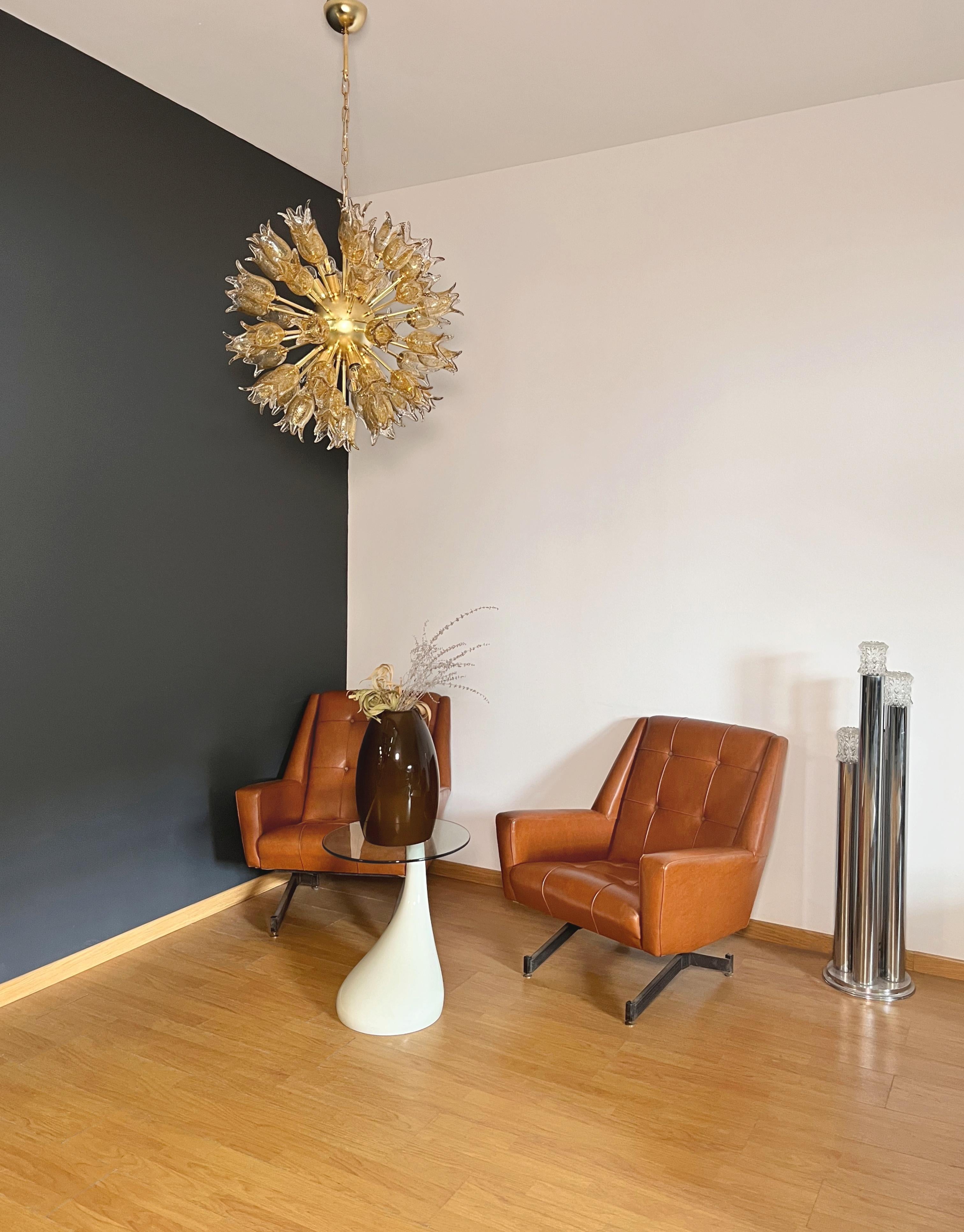 Questo elegante lampadario si distingue per il suo sofisticato design radiale. Con un'altezza totale di 120 cm (compresa la catena) e un diametro di 70 cm, è un pezzo forte ideale per spazi ampi e raffinati.
Realizzato in metallo placcato ottone,