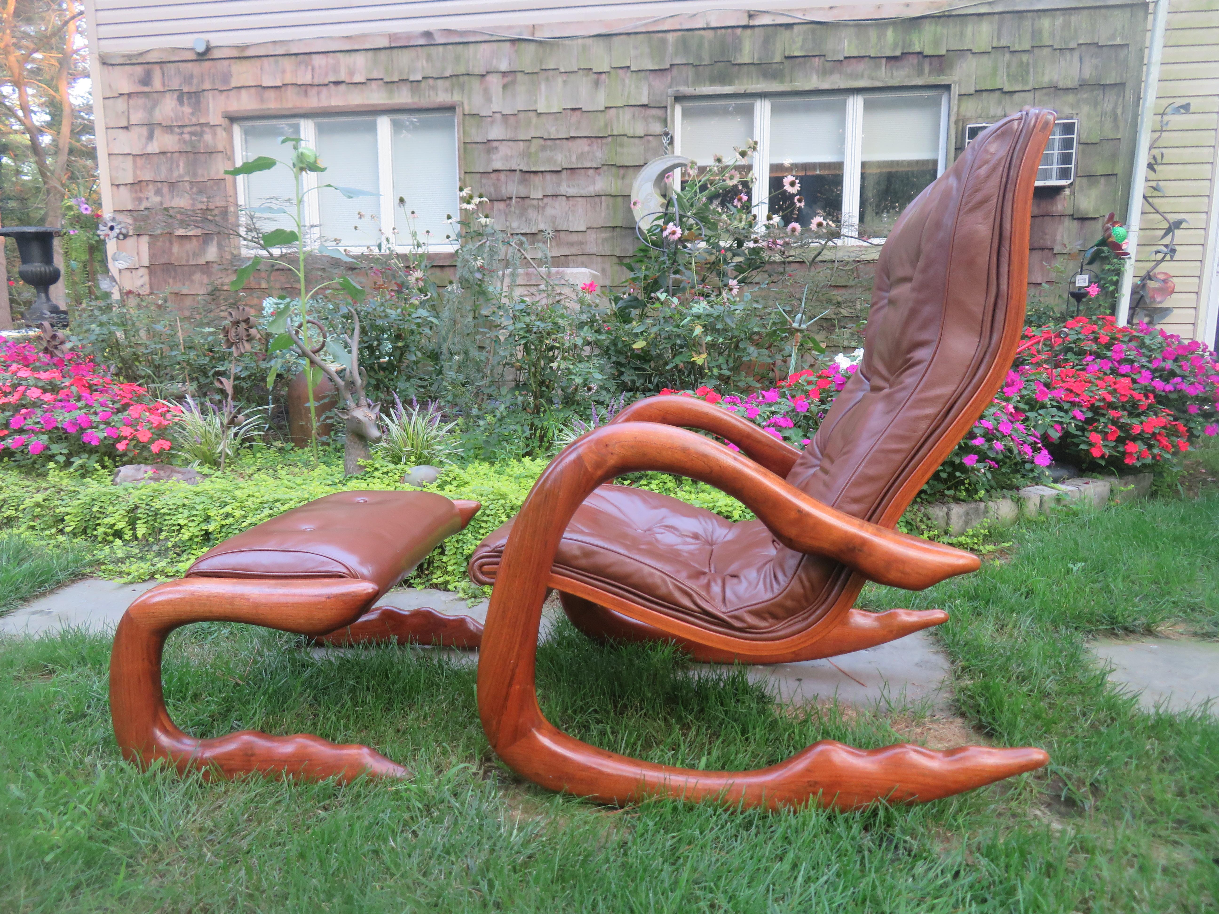 Fantastic organic modernist rocking chair and ottoman, hand-carved by Kentucky craftsman Bobby Falwell, a student of Wendell Castle. Each piece is signed and dated '77 on left leg. Features tufted brown bonded leather upholstery. Dimensions: (Chair)