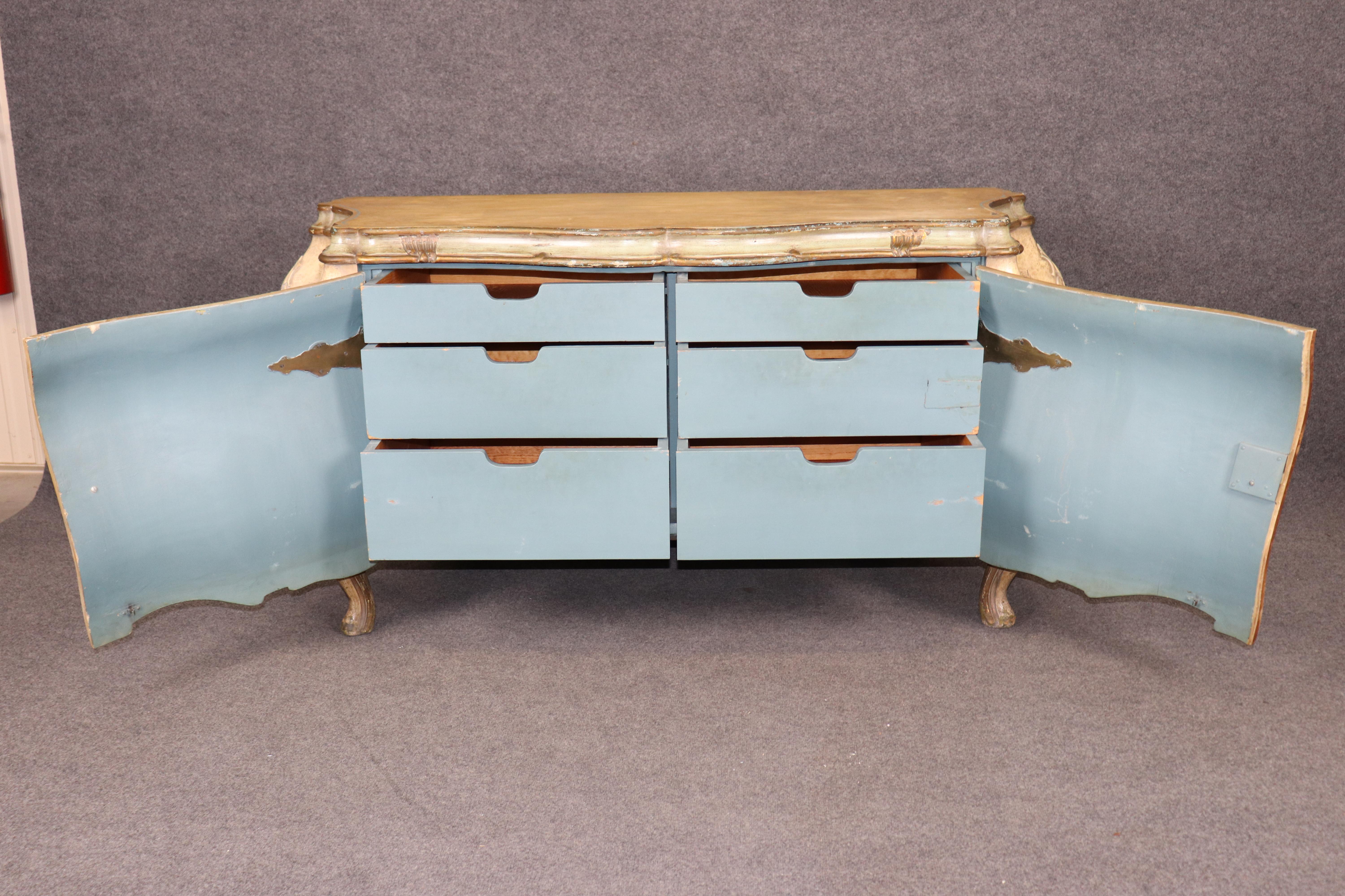 This is a gorgeous paint decorated bombe form Rococo sideboard or large commode made in Italy. The painted finish is distressed and has beautiful colors and a great original patina and finish. The piece has fitted drawers inside and dates to the