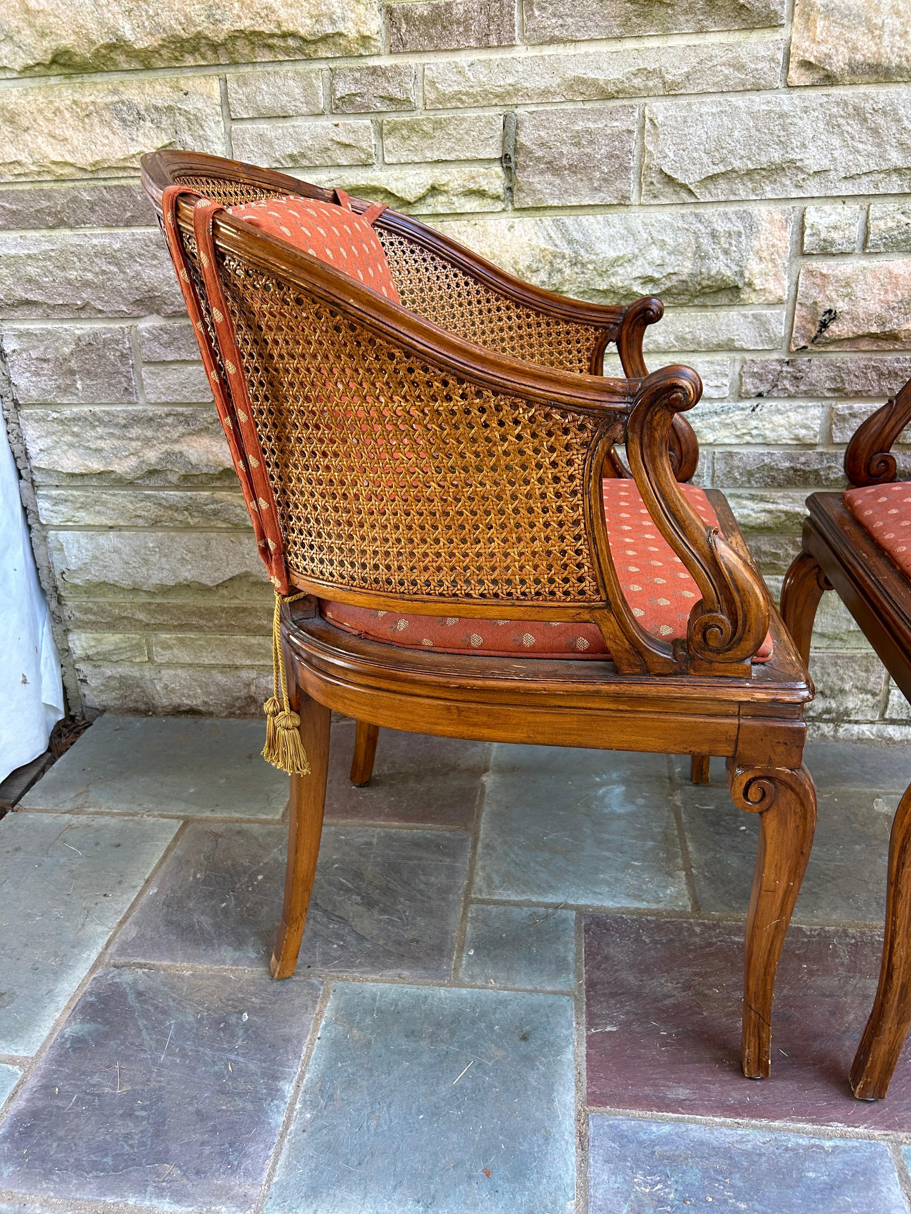 Fantastic pair of Hollywood Regency caned barrel back arm chairs.   These are high quality and do have some nice time worn patina to the finish.  They measure 37