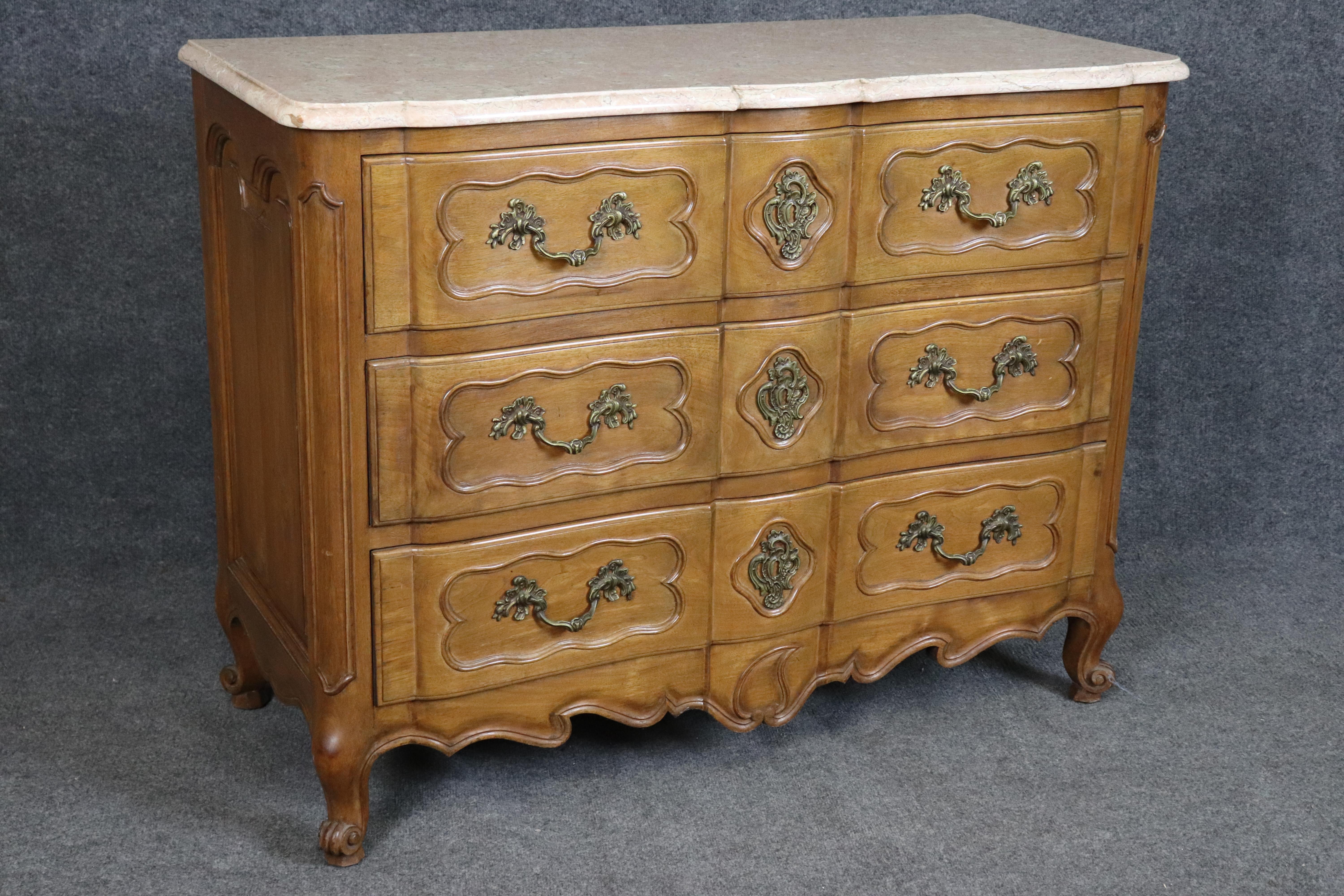 This elegant pair of French Louis XV style marble top commodes embodies timeless craftsmanship and refined European design. Each dresser features a beautifully shaped beige marble top, softly contoured to match the serpentine lines of the case. The