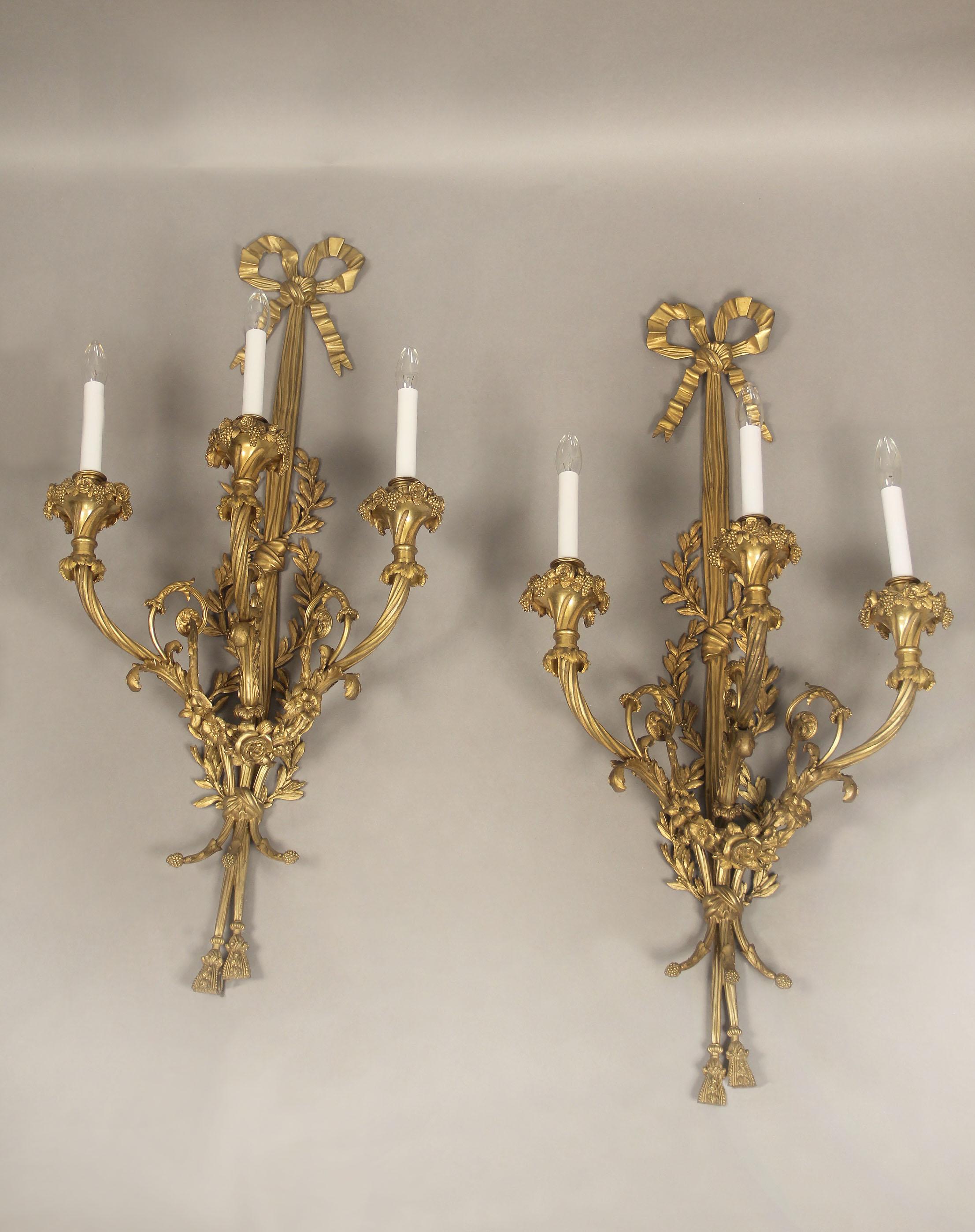 A fantastic quality pair of late 19th century gilt bronze three light sconces.

By Maison Millet

The finely chiseled sconces with spiral arms decorated with leaves and berries, the body centered with swags of roses and flowers, the top with a