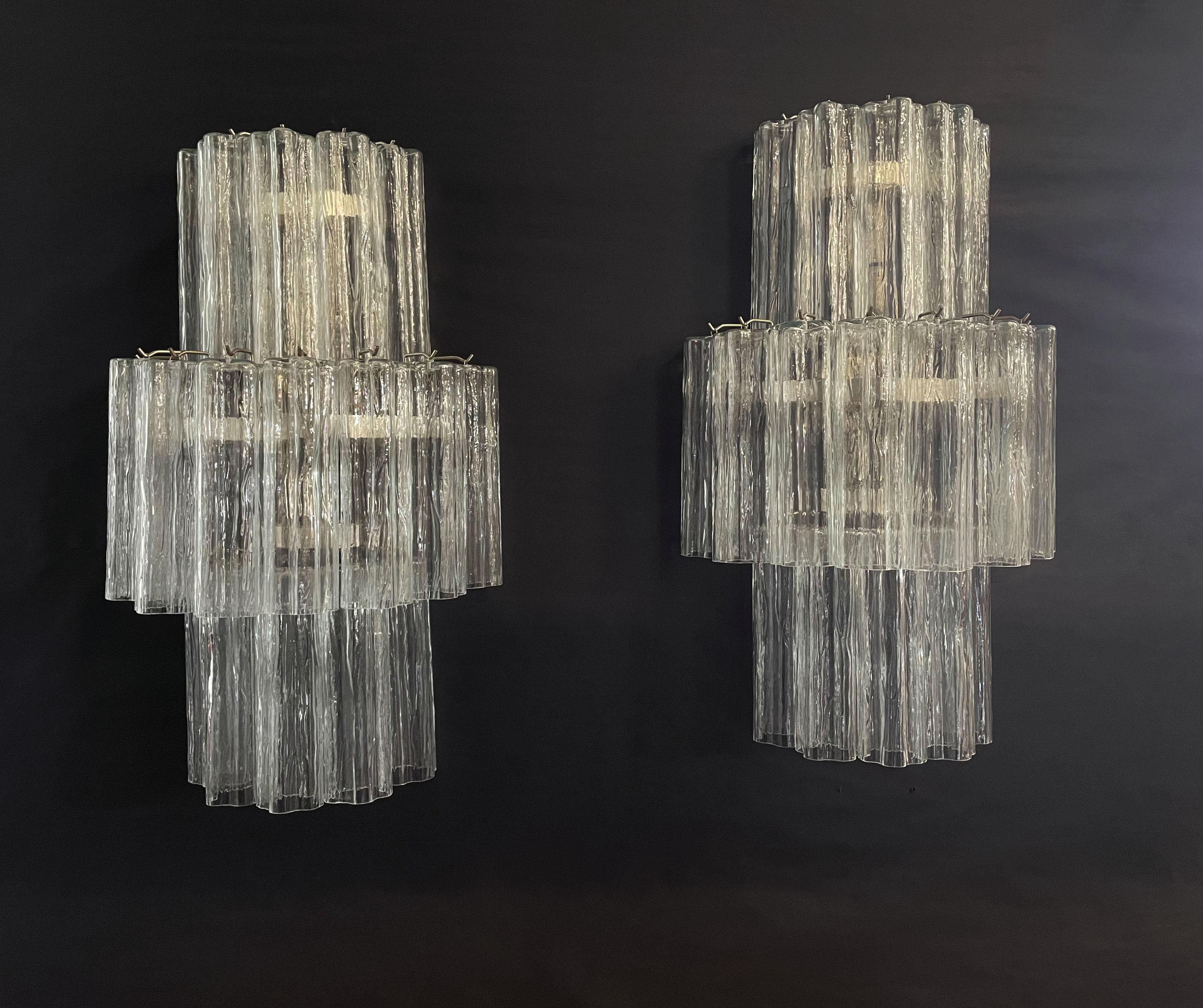 Italian vintage pair of wall sconces in Murano glass and nickel-plated metal structure. The armor polished nickel supports 18 large clear glass tubes in a star shape for each lamp.
Period: late XX century
Dimensions: 29 inches height (75 cm); 17