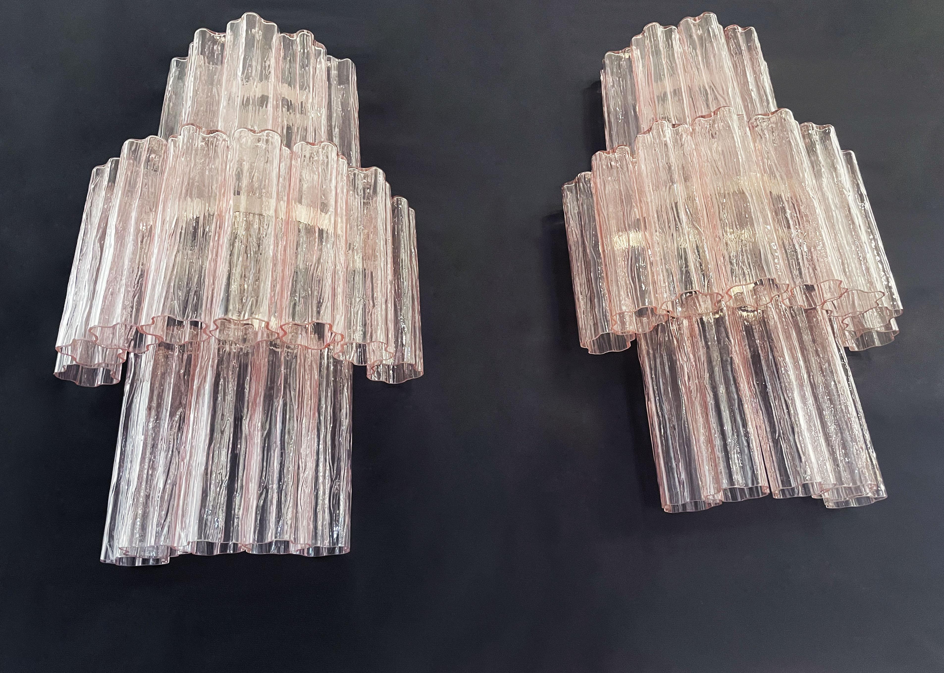 Italian vintage pair of wall sconces in Murano glass and nickel-plated metal structure. The armor polished nickel supports 18 large pink glass tubes in a star shape for each lamp.
Period:	late XX century
Dimensions:	29 inches height (75 cm); 17