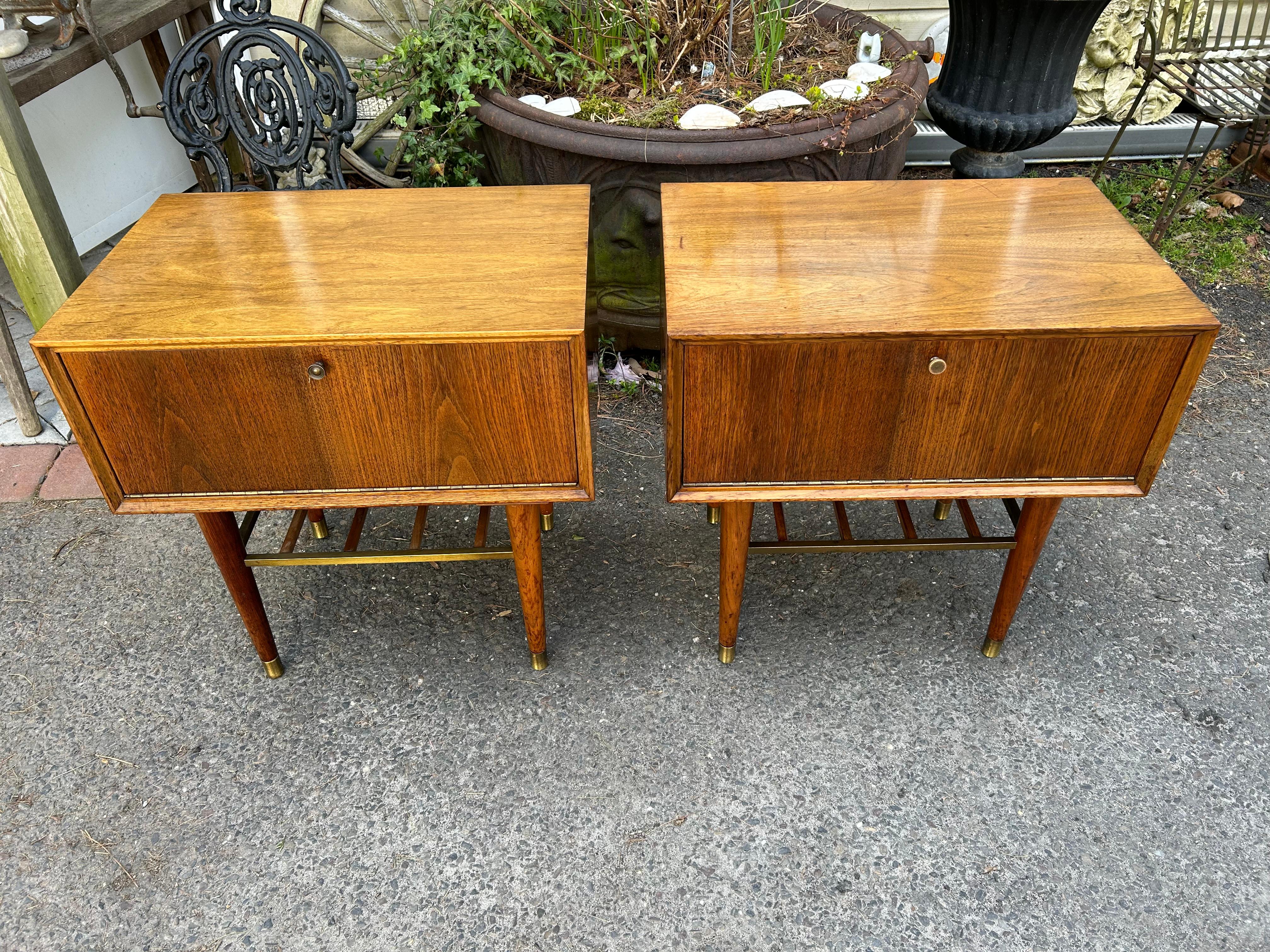 Fantastic pair of Paul Mccobb style walnut drop down door night stands.  These were actually made in the style of Paul Mccobb by the Furnette Furniture Company.  We love the drop down door with formica inside to use as a table top-great for your
