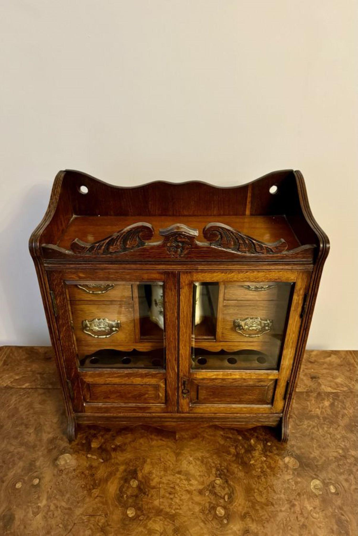 Fantastique cabinet de fumeur en chêne sculpté de l'époque édouardienne, avec une caisse en chêne sculpté, deux portes en verre à l'avant s'ouvrant pour révéler des compartiments pour les cigares, les boîtes d'allumettes et les accessoires de