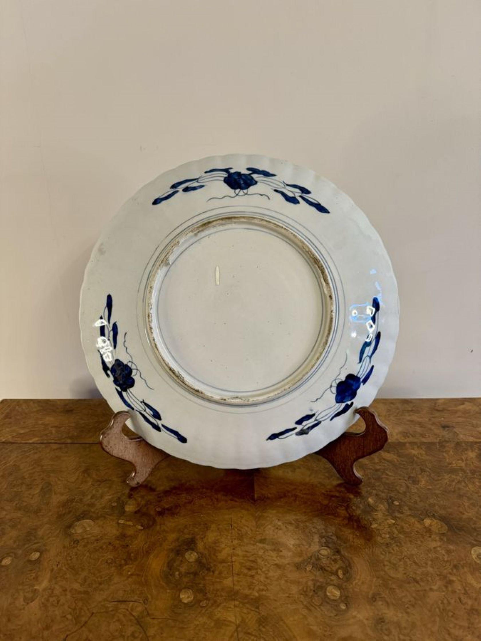 Fantastique assiette imari japonaise ancienne de qualité, avec un bord en forme de feston, décorée d'un panier de fleurs au centre entouré de rinceaux, de feuilles, de fleurs et d'arbres peints à la main dans des couleurs rouge, blanc, bleu et or.