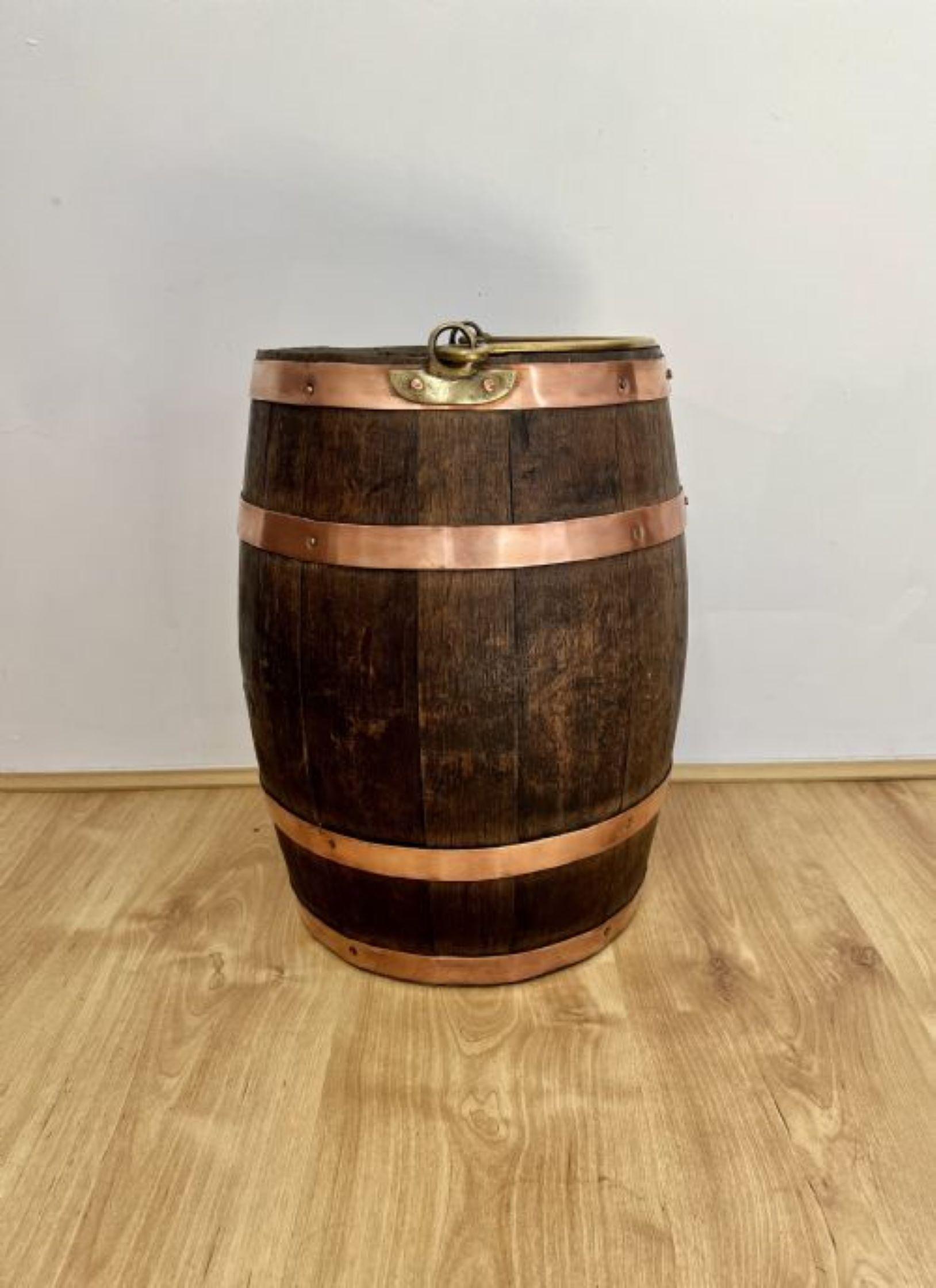 Fantastic quality antique Victorian oak log bin with copper bands having a fantastic quality antique Victorian oak log bin in the form of a barrel with copper bands, a brass swing handle to the top standing on a circular base.
