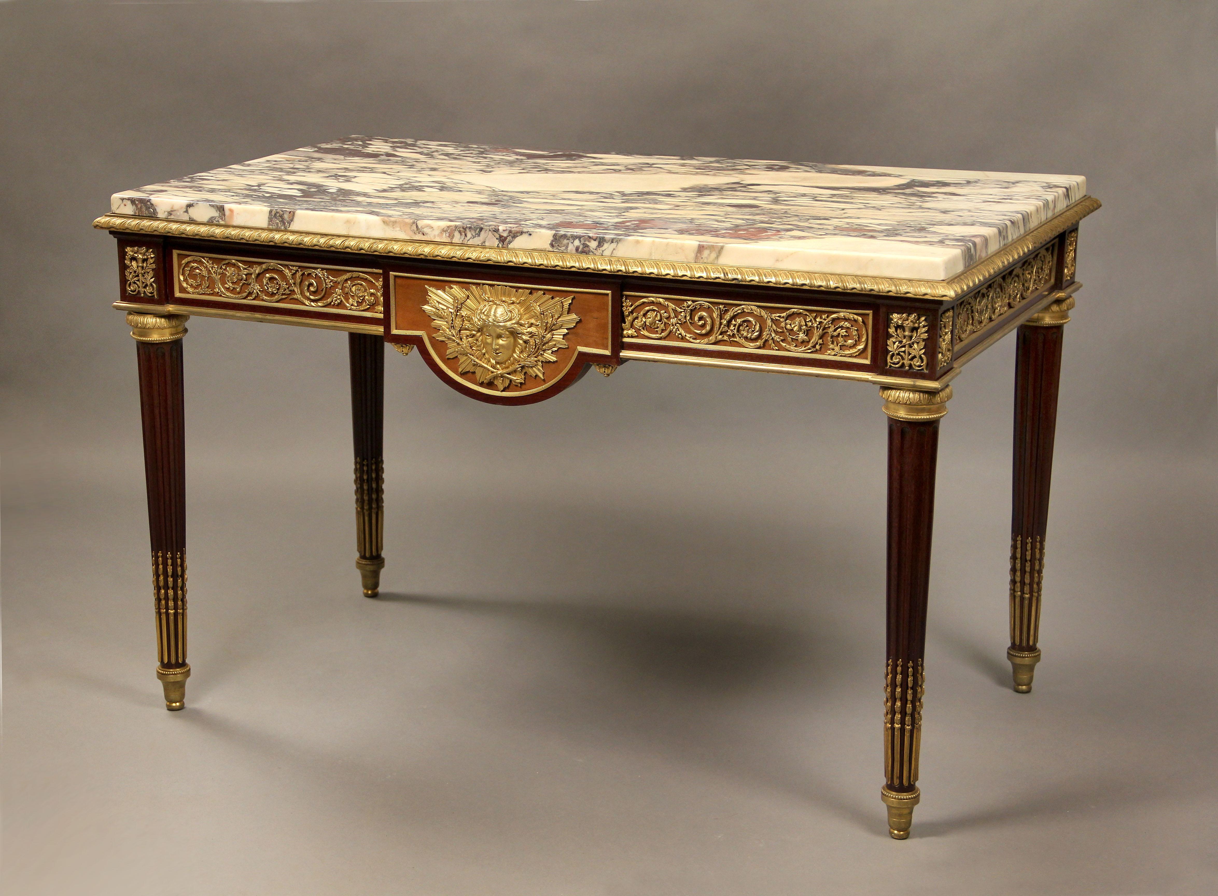 A Fantastic Quality Late 19th Century Gilt Bronze Mounted Louis XVI Style Center Table By Lexcellent

Guillaume-Edmond Lexcellent

A nice marble top above a bronze frieze, the table centered with a sunburst mask of Apollo with crossed olive