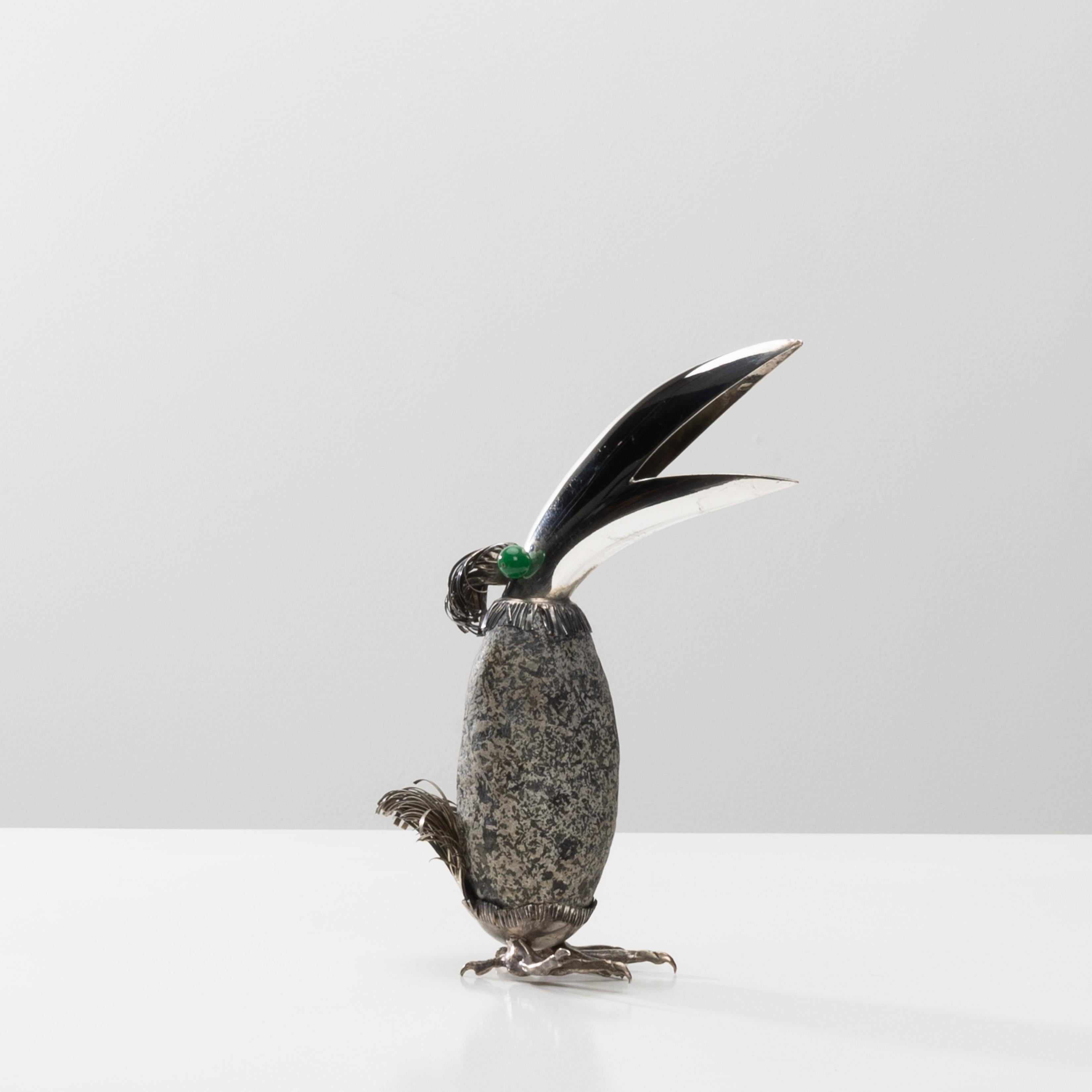 Fantastico uccello d'argento (tucano) di Gabriele De Vecchi, Milano (IT).
Il corpo è formato da un ciottolo affiancato da un becco d'argento e dotato di coda e zampe.
Occhi di pietra dura (probabilmente onice verde).
Marchi del maestro e titolazione