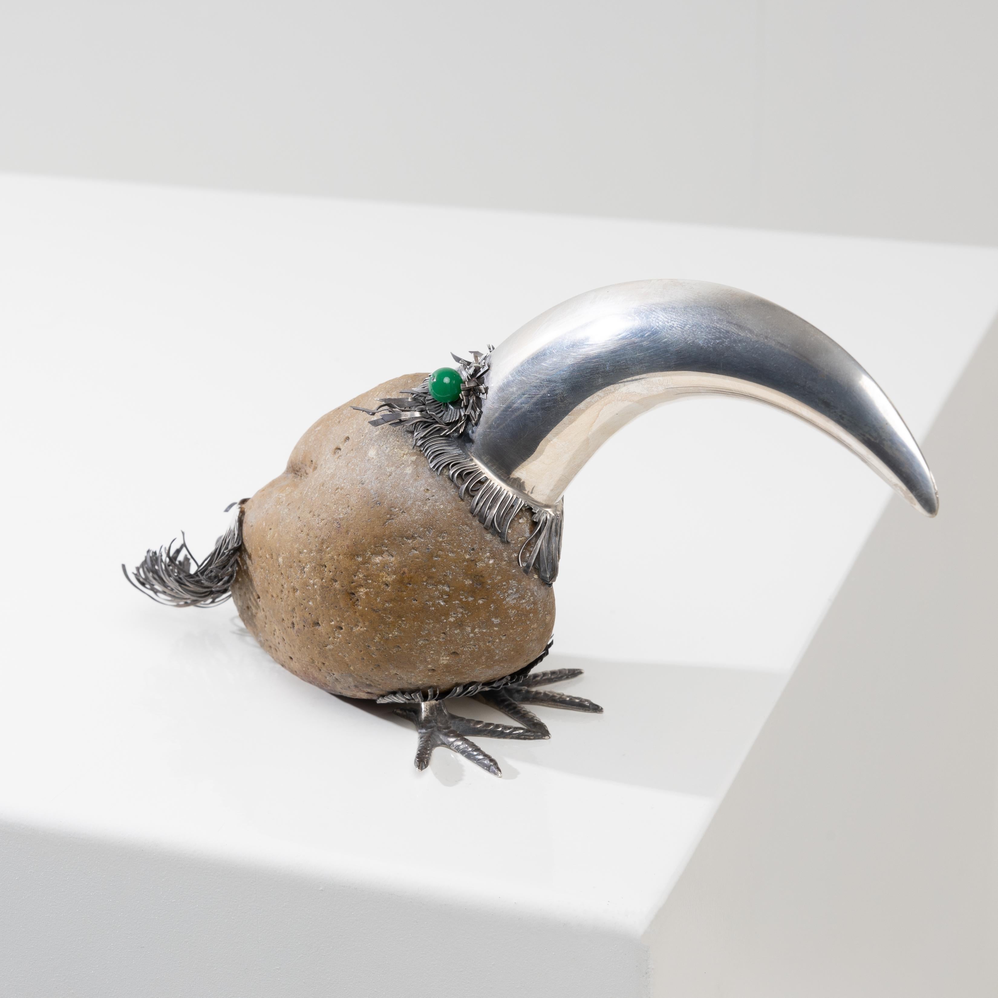 Fantastico uccello d'argento (tucano) di Gabriele De Vecchi, Milano (IT).
Il corpo è formato da un grande ciottolo affiancato da un imponente becco d'argento e dotato di coda e zampe decorate.
Occhi di pietra dura (probabilmente onice verde).
Marchi