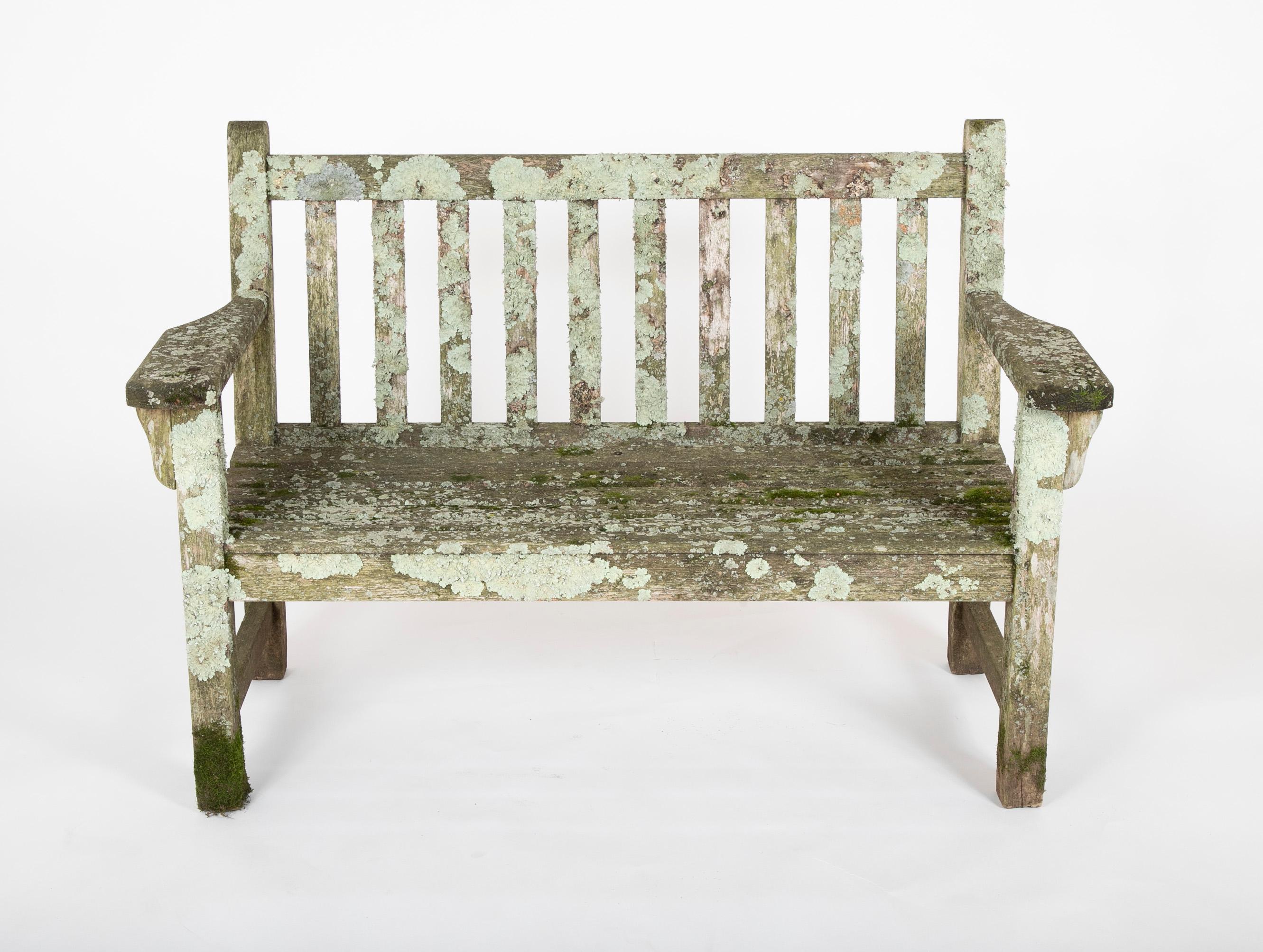 Weathered teak wood bench having fantastic lichen and moss patination.