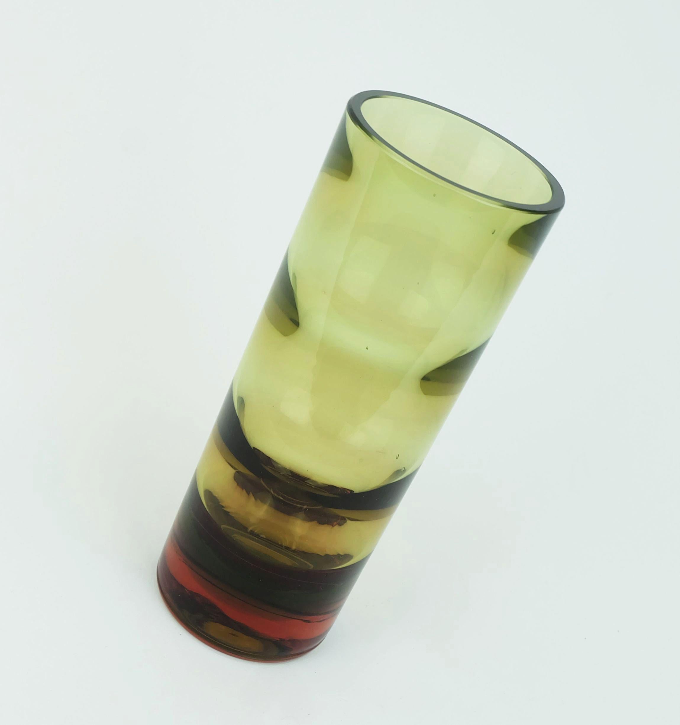 Un bellissimo vaso di cristallo tedesco della metà del secolo scorso. Progettato da Erich Jachmann per WMF negli anni Sessanta. L'esterno è dritto, l'interno è ondulato. Lo spettro di colori va dall'ambra al verde fino al color ruggine della base.