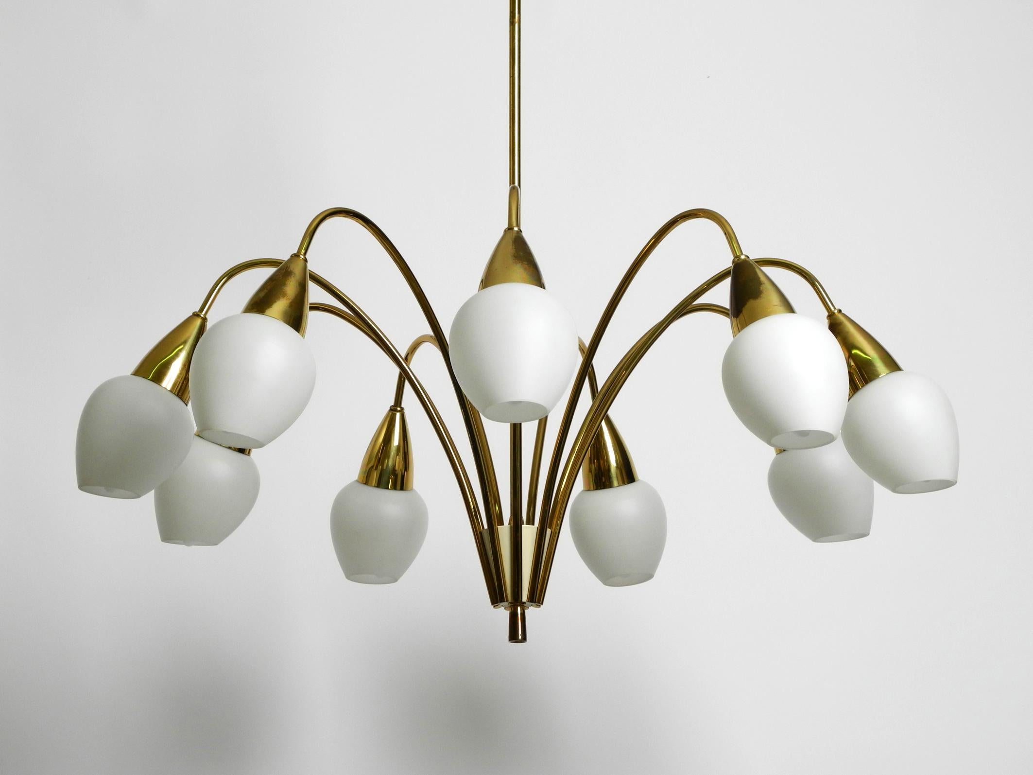 Beautiful, rare 9-armed large Mid Century brass chandelier with opal glass shades.
A very high quality lamp with lots of details.
Beautiful 1950s design. Entire frame is made of brass.
Very good condition and fully functional. No damage to the