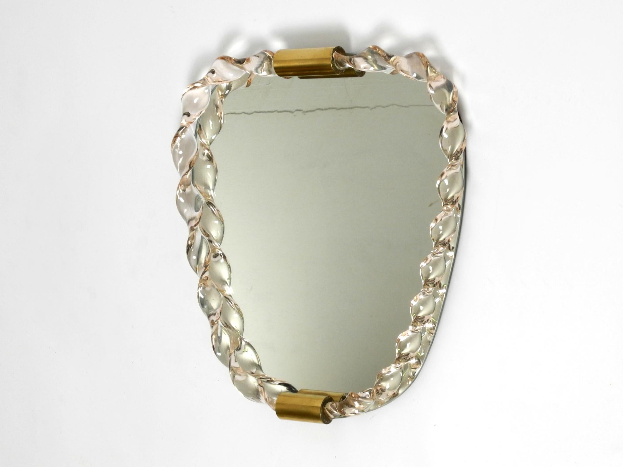 Stunning 1960s wall mirror with twisted Murano glass frame.
Very high quality workmanship in very good condition with a beautiful light patina.
Heavy thick frame made of solid light pink transparent Murano glass.
No damage to the entire mirror. No