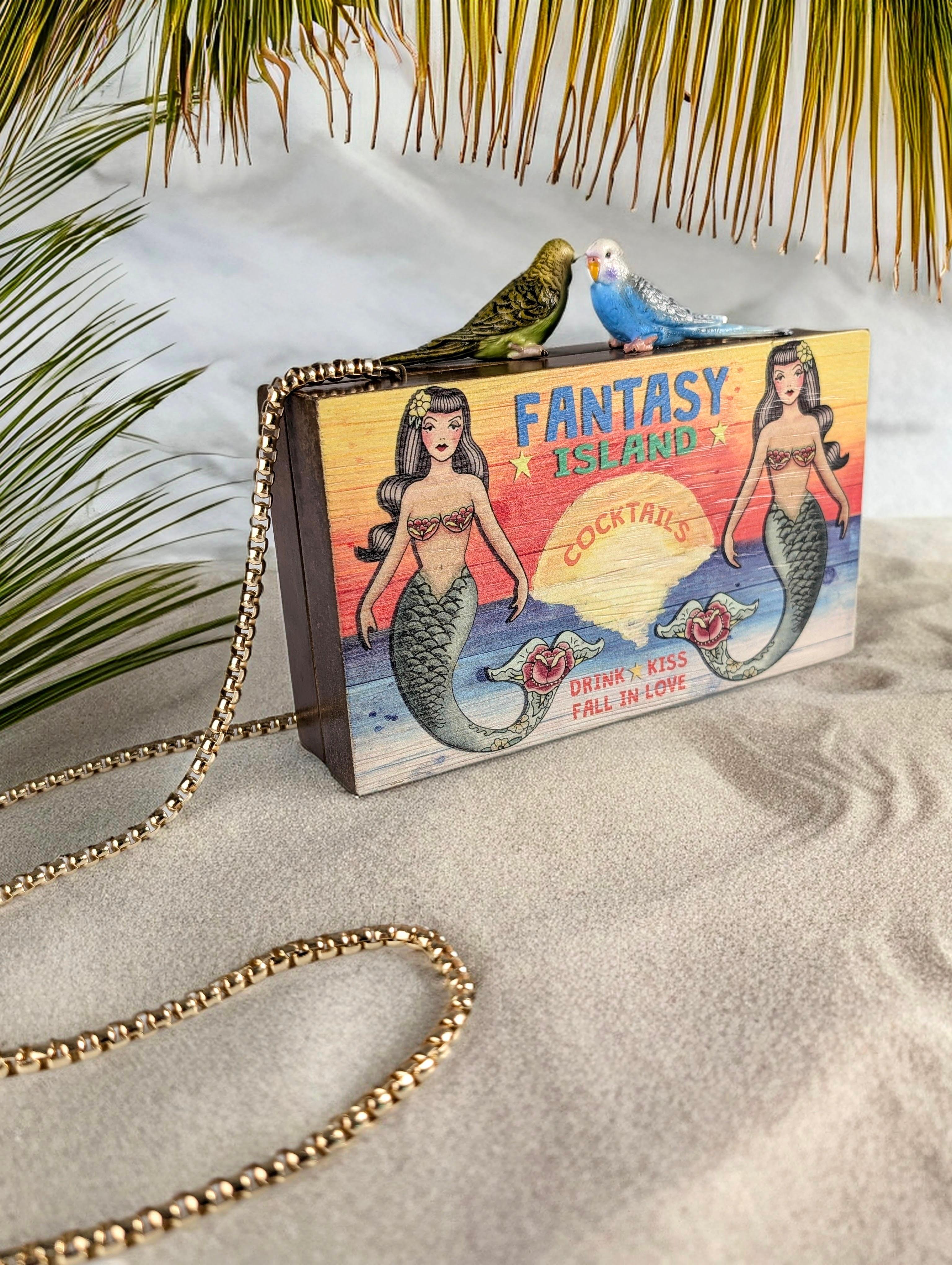 This clutch bag from Sarah's Bag will transport you to a tropical paradise. Made of wood and adorned with a vibrant illustration that evokes the magic of a fantasy island, this bag is perfect for adding a stylish touch to your evening looks.

The
