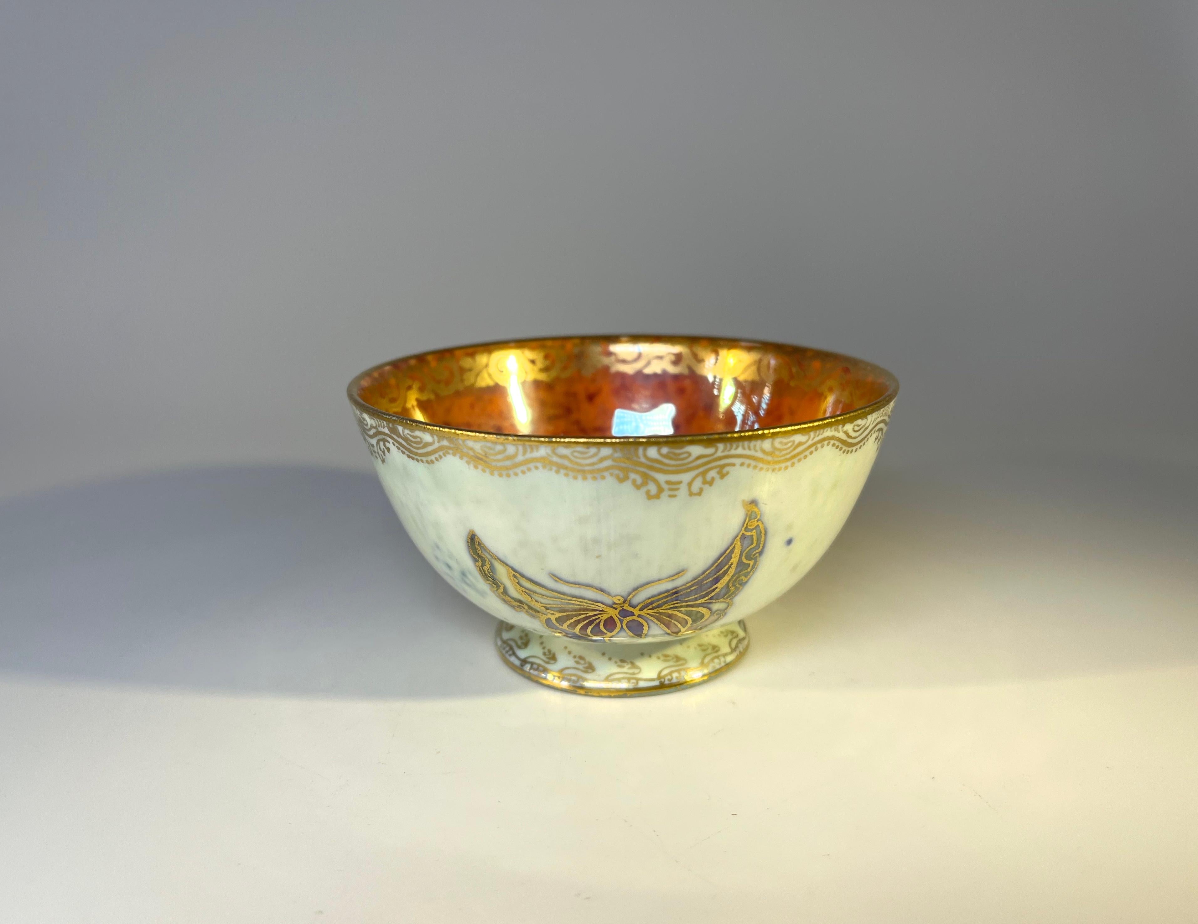 Bone china Ordinary York cup by Daisy Making-Jones for Wedgwood
Decorated on the outer with a trio of hand painted and gilded butterflies, a ground of cream pearl lustre and gilded filigree rim.
The inner has a vivid orange mottled ground, surpassed