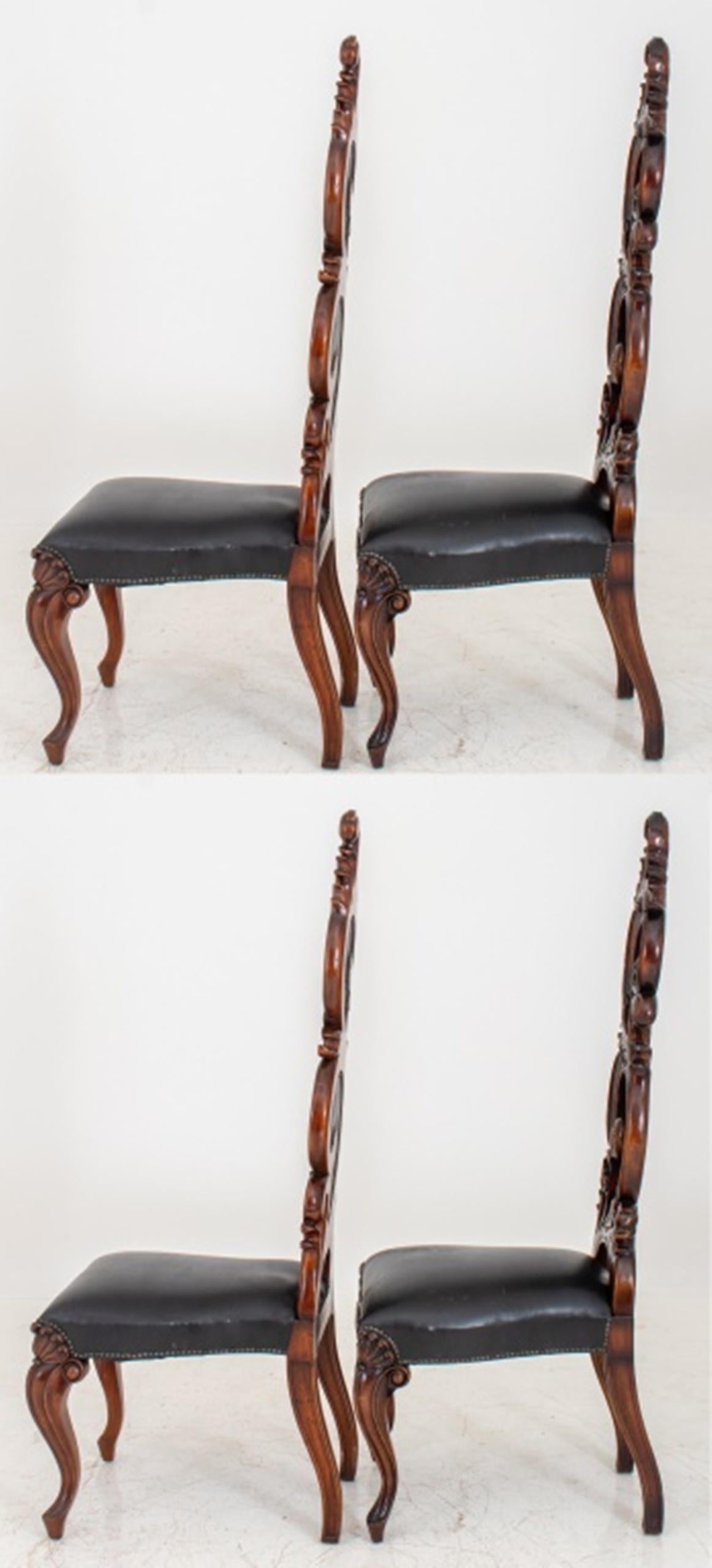 Four Fantasy Rococo dining chairs, the body carved with a swirling acanthus design punctuated by black leather inserts and hammered tacks on the back, seat upholstered black leather, cabriole legs accentuated with anthemia.

Dimensions: 61.5