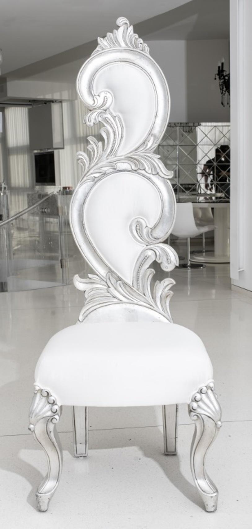 Pair of Fantasy Rococo silvered wood dining chairs, the body carved with a swirling acanthus design punctuated by white fabric inserts and hammered tacks on the back, seat upholstered white fabric, cabriole legs accentuated with anthemia, unmarked.