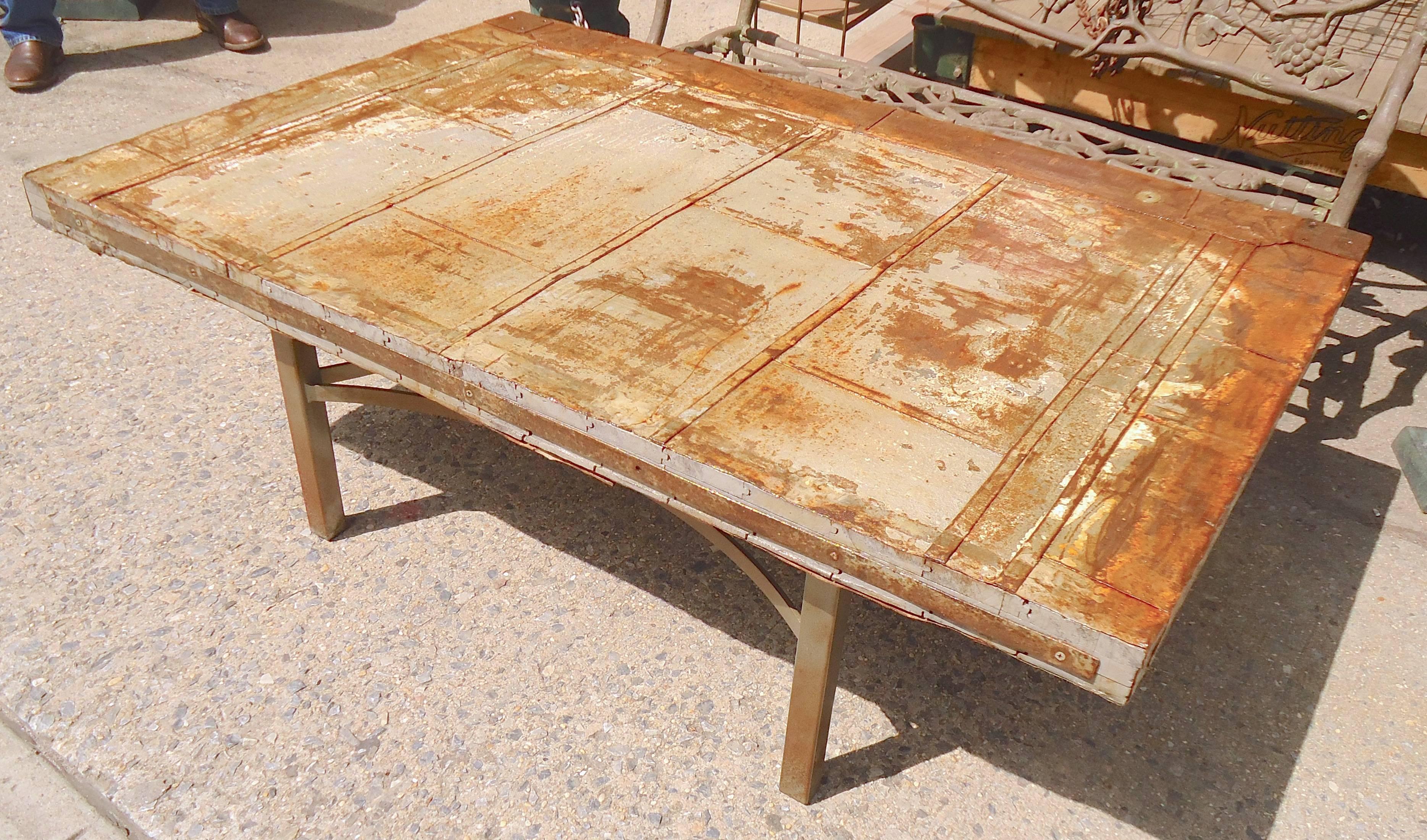 Industrial style coffee table with metal base and a cut metal door as the top.
(Please confirm item location - NY or NJ - with dealer).
   
  
 