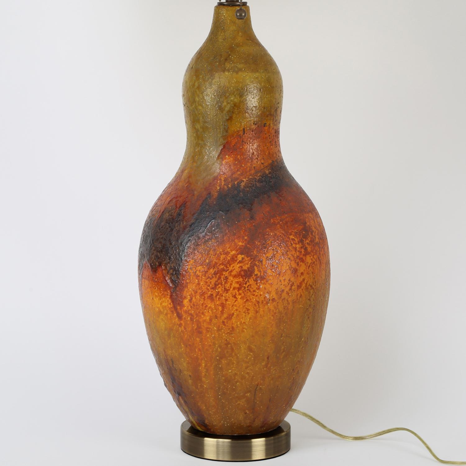 Artisan ceramic table lamp, hand-thrown with volcanic orange and yellow glaze and bronze base and hardware, by Marcello Fantoni, Italian 1960's. Height is adjustable.

Measures: Shade diameter 18 inches
Shade height 12 inches.