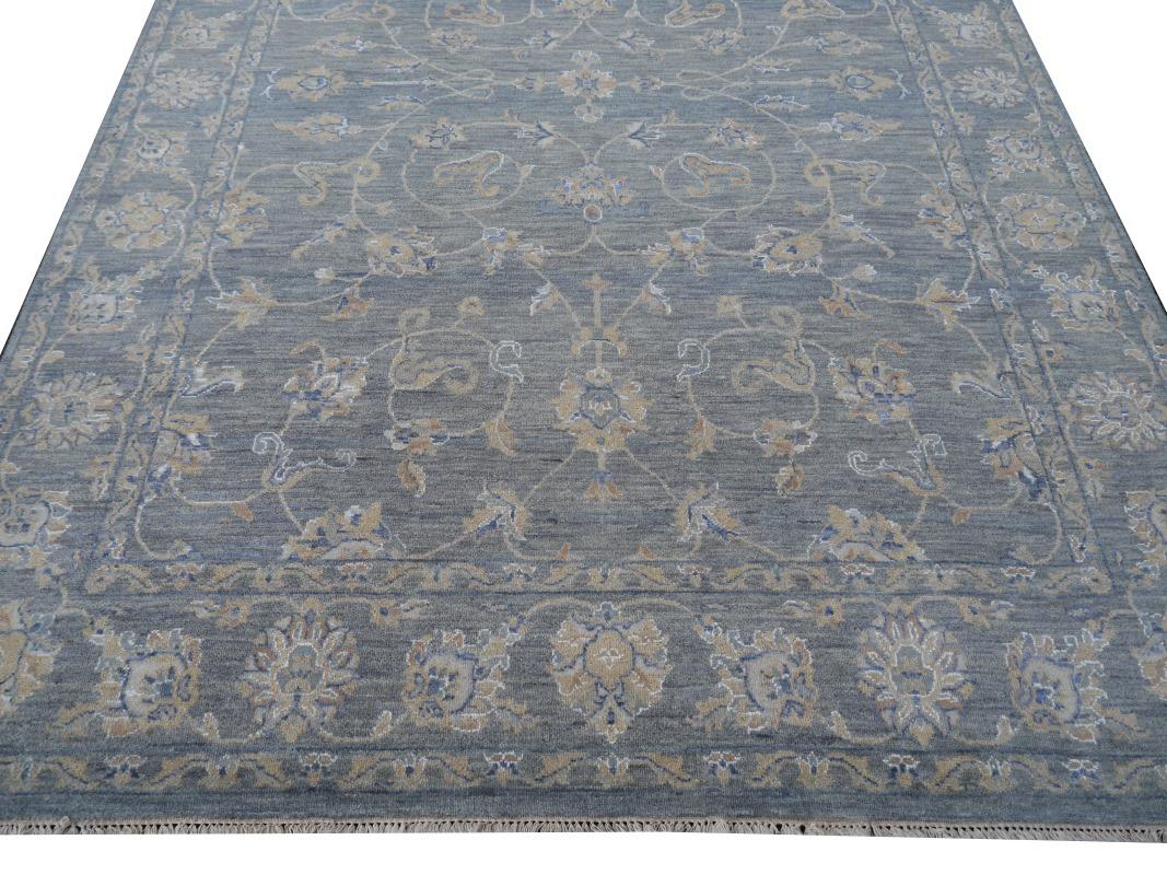 An area sized rug with design in style of Farahan.
This beautiful rug was hand knotted to fit 21st century interior needs. The background is in an elegant blue gray beige color with floral designs.
Farahan design rugs are very looked after since