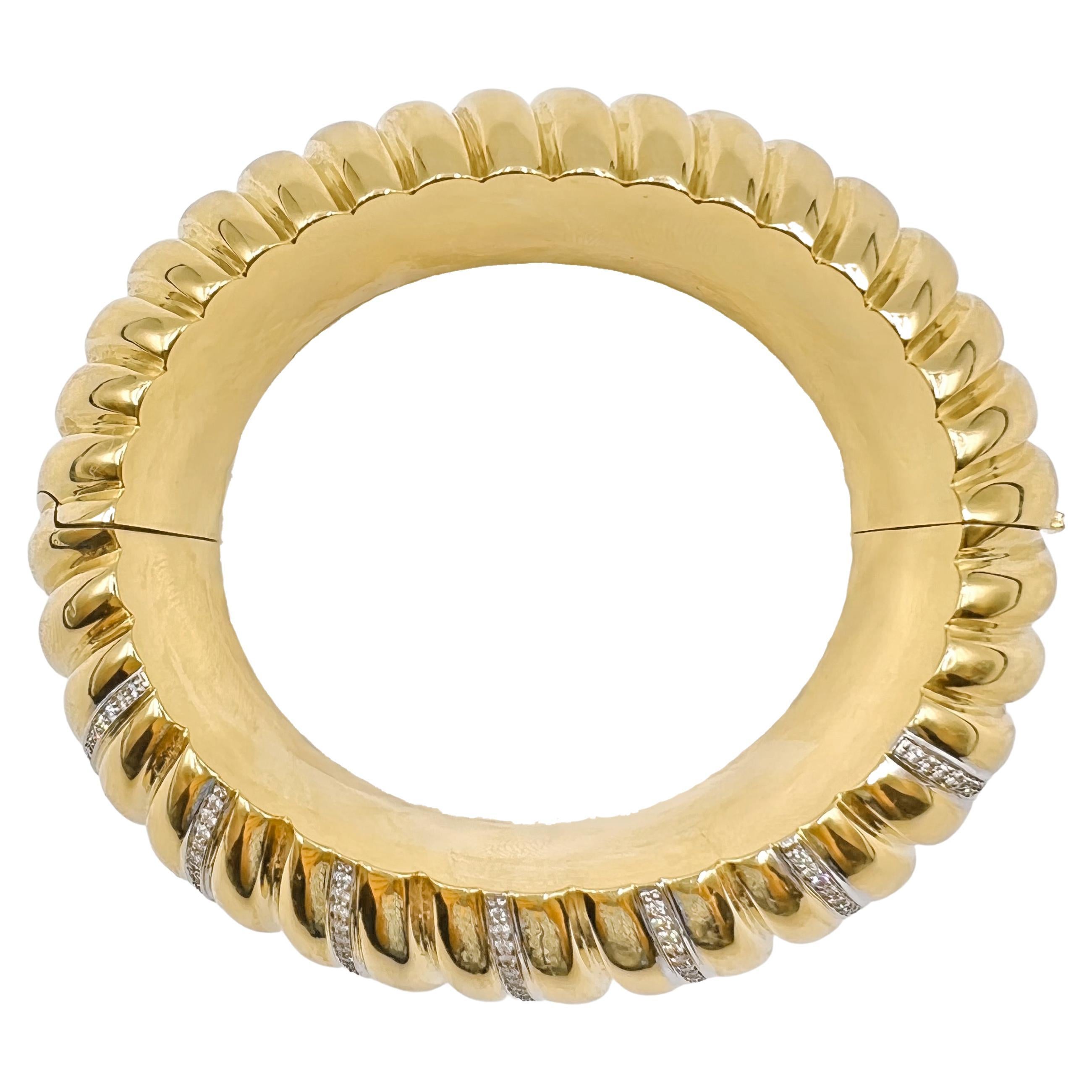 Wide oval-shaped bangle in polished and fluted 18k yellow gold, accented by seven rows of round-cut diamonds.  182 diamonds weighing approximately 1.80 total carats.  Hinged clasp with push button release.  Stamped 'RFMAS' for Faraone Mennella,